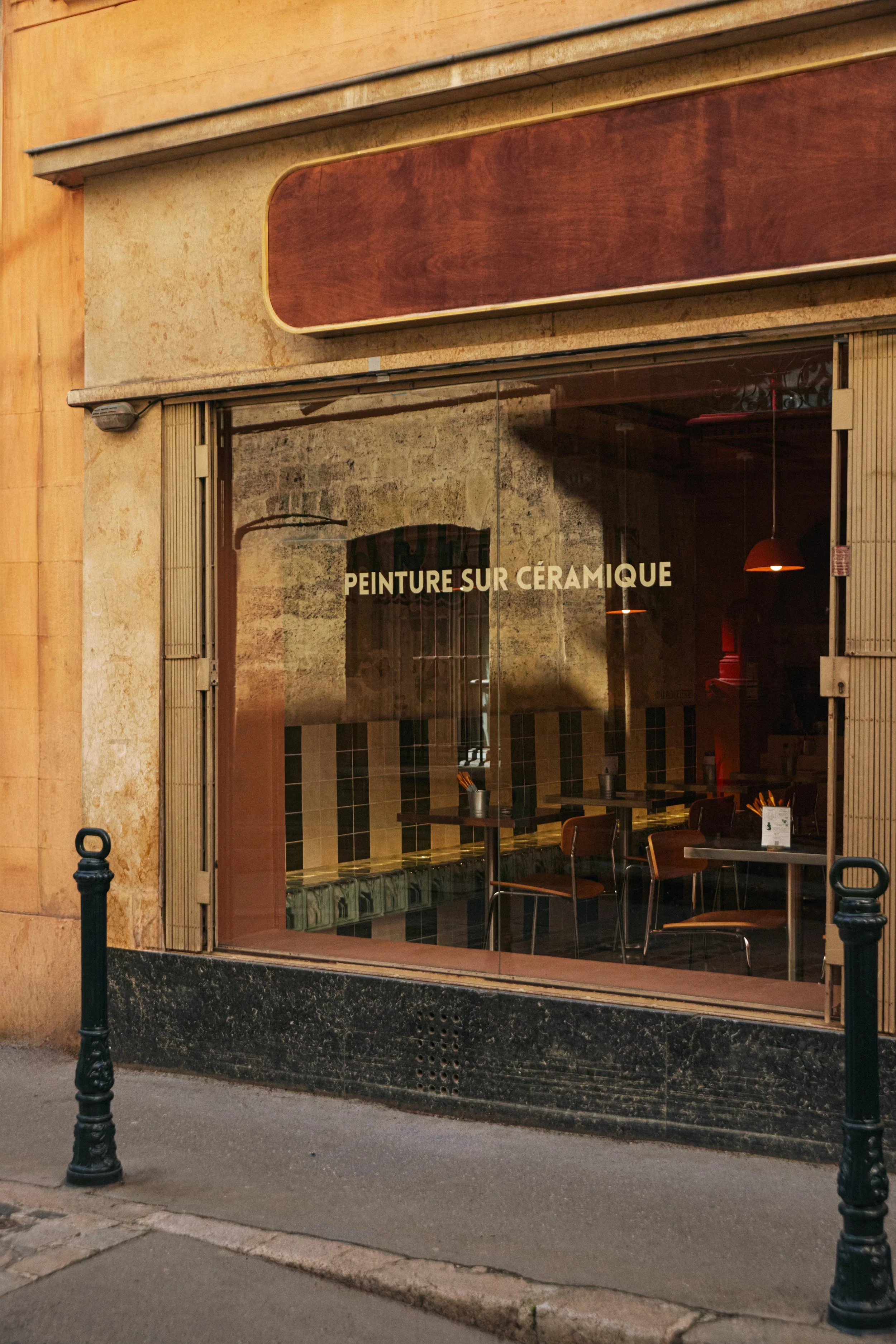 Vue sur la vitrine du café-atelier Barbotyne, mettant en scène l’activité de peinture sur céramique.
Pensée comme un prolongement du lieu, elle permet de rendre visible l’expérience proposée depuis l’extérieur.
Ce travail d’agencement et de design re