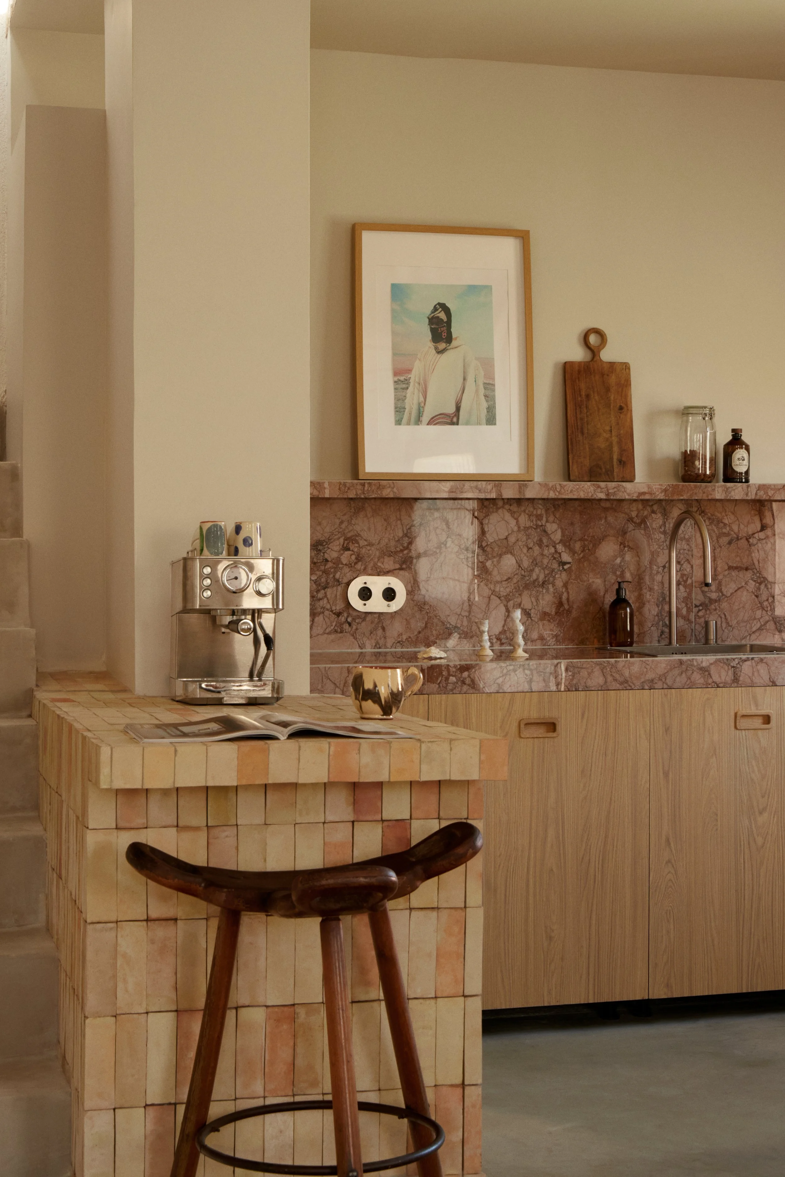 Détail d’une cuisine conçue par Local Club dans une maison rénovée à Marseille. Îlot en carreaux de terre cuite, façades en bois et pierre marbrée composent un espace inspiré de l’artisanat méditerranéen.