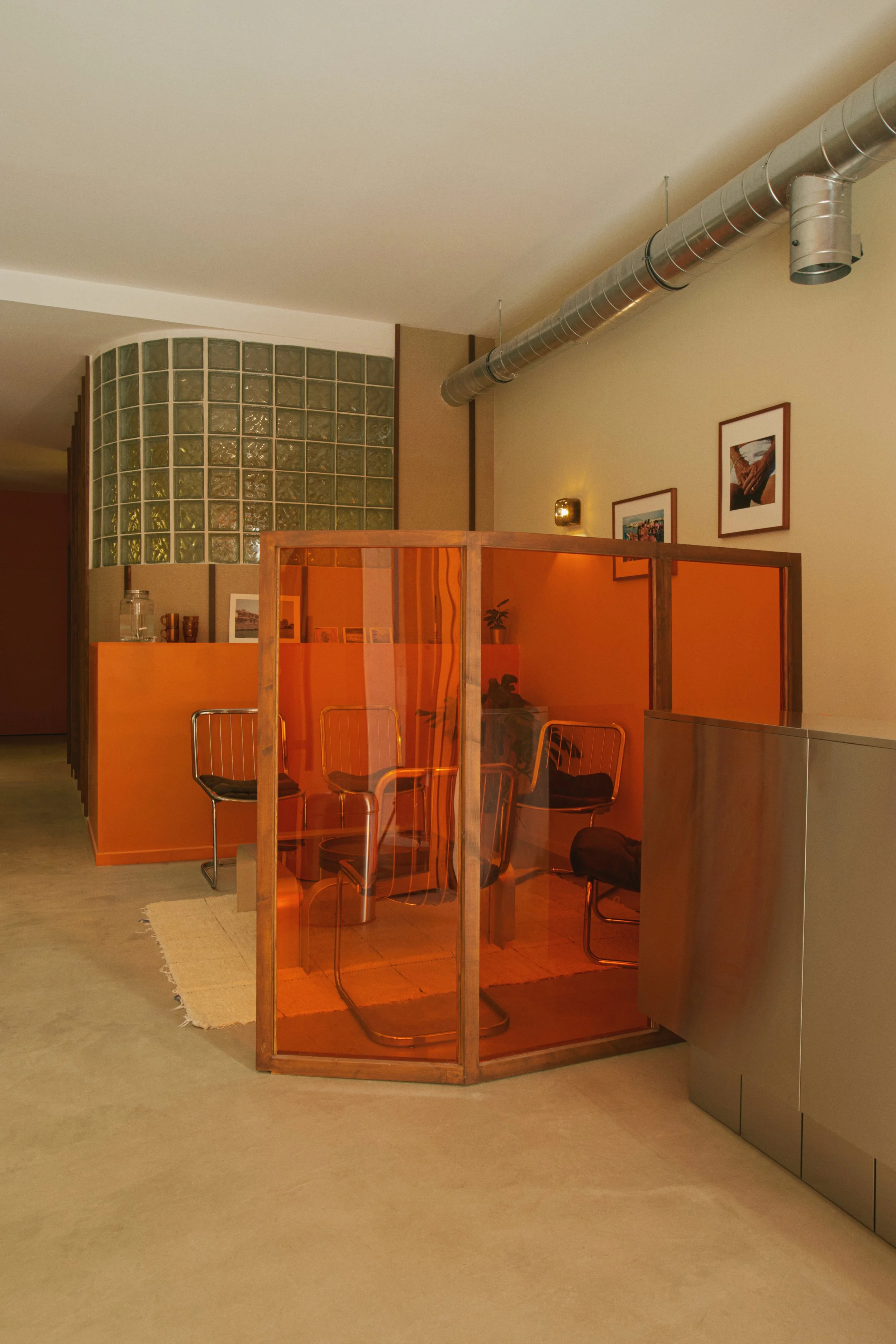 Espace d’attente d’un centre de détatouage laser à Marseille imaginé par Local Club. Architecture intérieure structurée par une cloison translucide orangée, créant une séparation douce et une ambiance chaleureuse dans un lieu de soin.