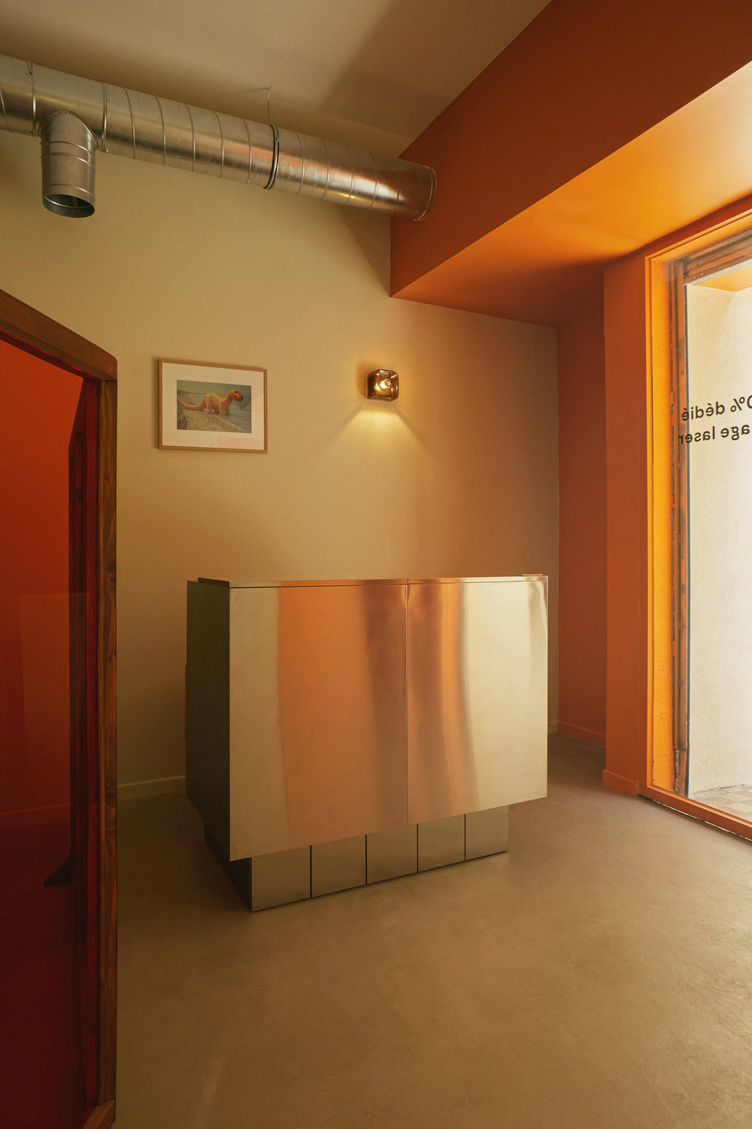 Comptoir en inox d’accueil d’un centre de détatouage laser à Marseille conçu par Local Club. Architecture intérieure mêlant volumes simples, inox et lumière chaude, pour un espace à la fois fonctionnel et apaisant.