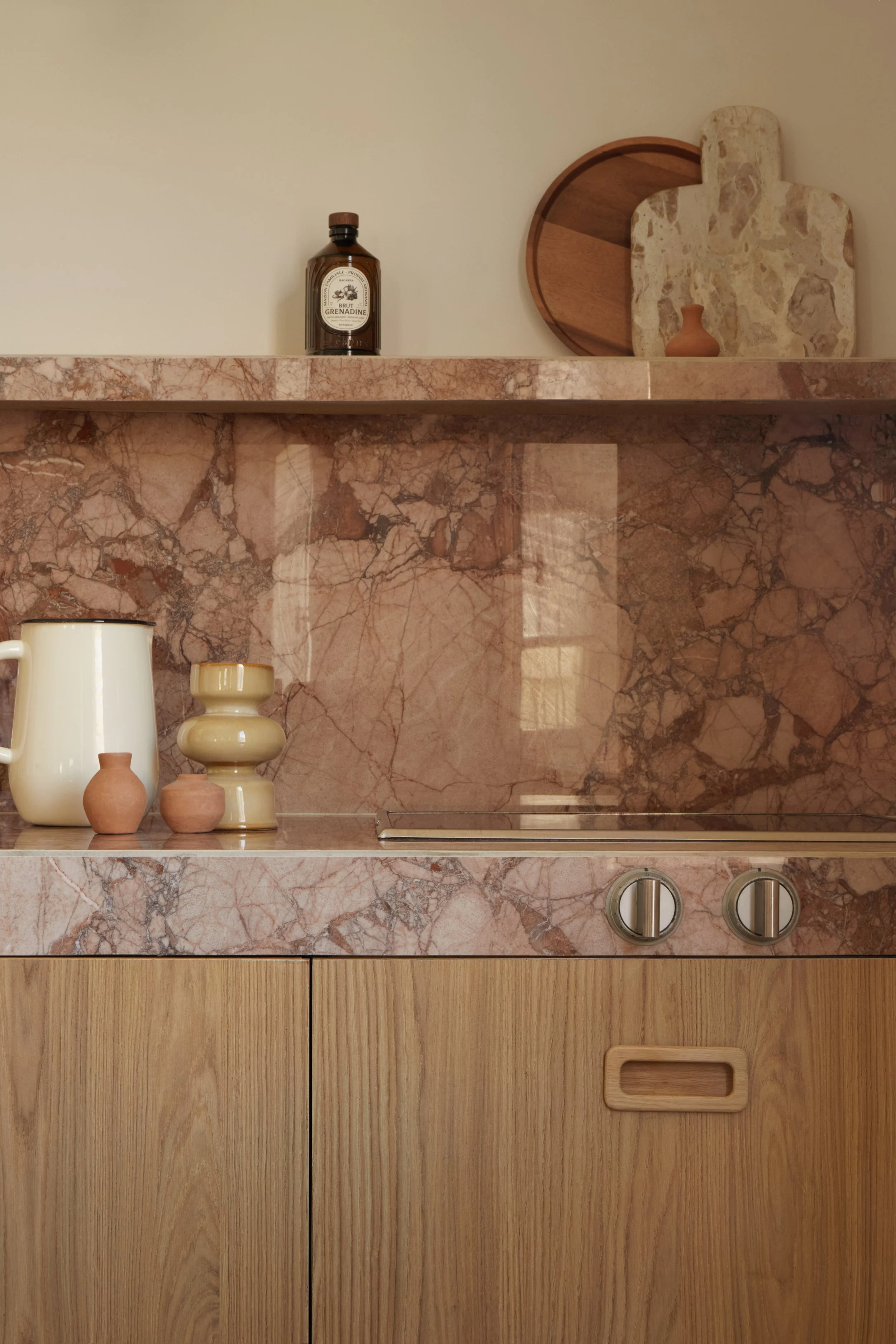 Détail d’une cuisine contemporaine réalisée par Local Club à Marseille. Association de marbre rosé, bois texturé et objets aux tonalités minérales dans un intérieur inspiré du modernisme méditerranéen.