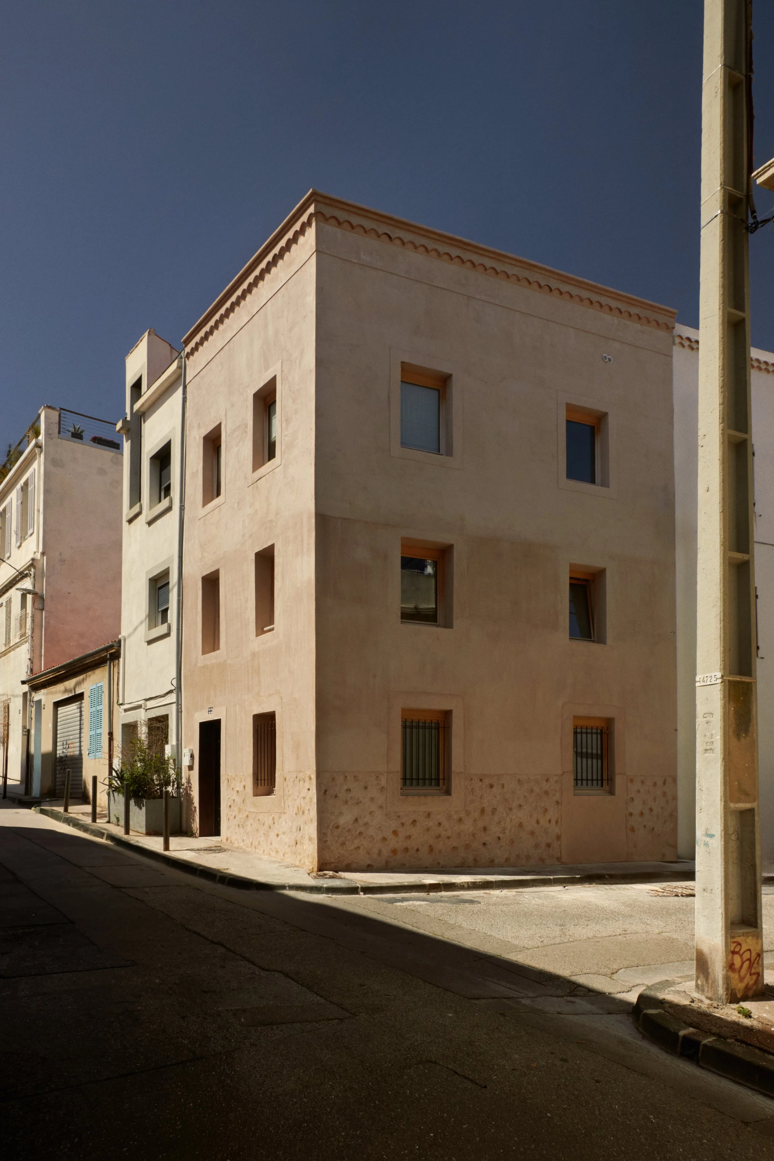 Façade de cette maison de ville rénovée dans le quartier de Samatan à Marseille par Local Club. Une réhabilitation sobre et contemporaine qui révèle les volumes existants, les textures minérales et l’architecture méditerranéenne du bâtiment.
