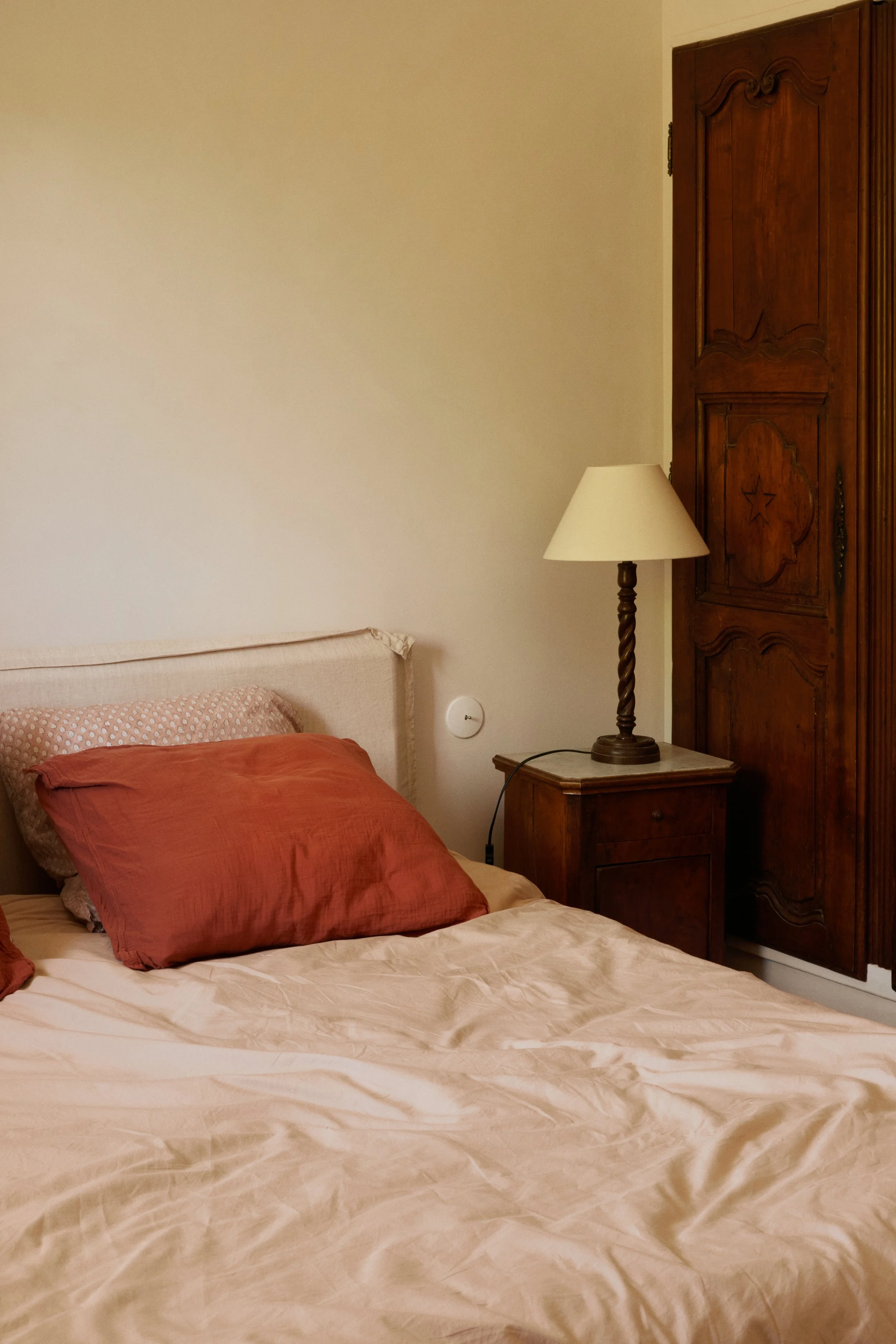coin chambre oreiller rouge table de nuit en bois foncé