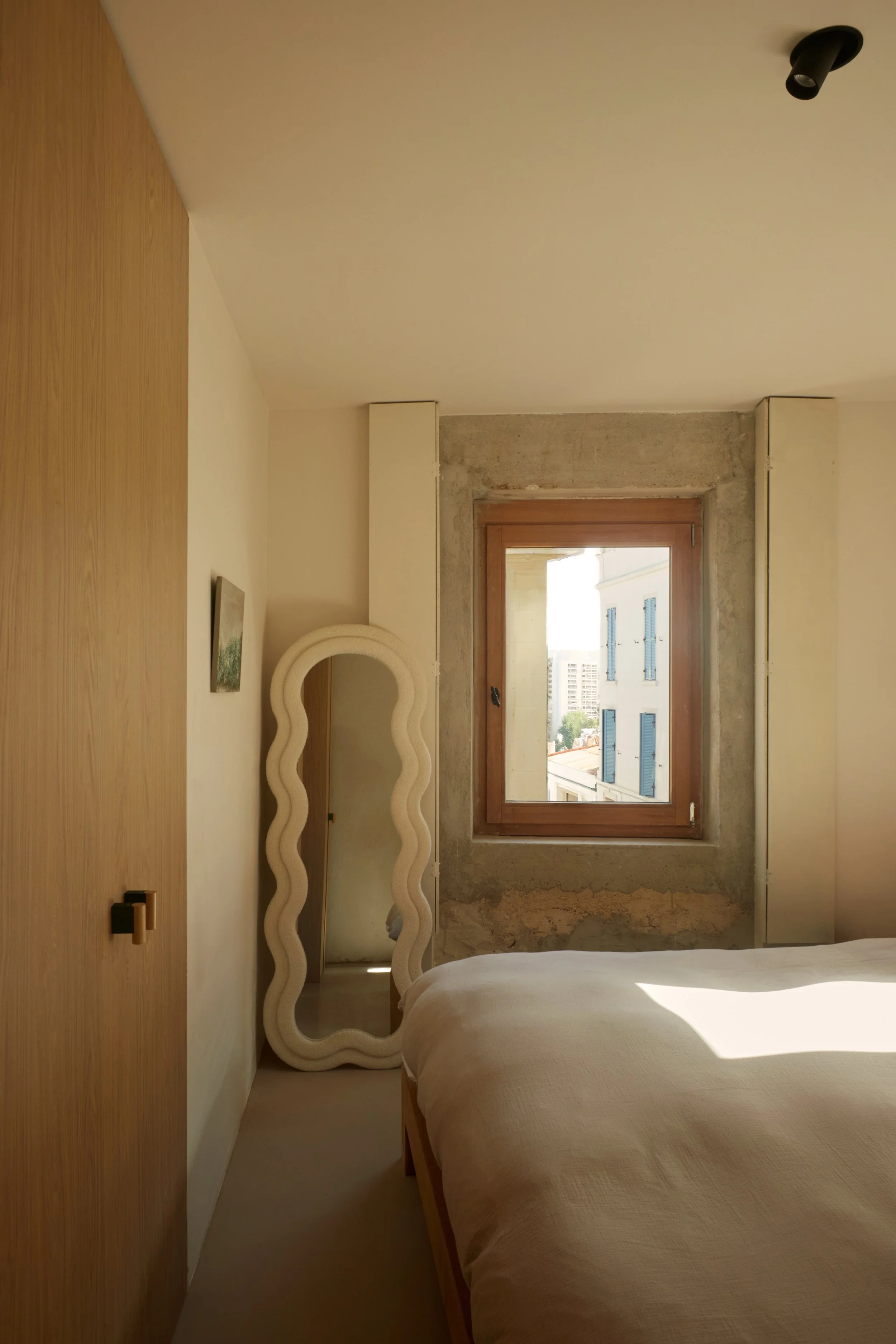 Chambre d’une maison située dans le quartier Samatan à Marseille, rénovée par Local Club. Matières brutes, menuiseries en bois et lumière naturelle composent un intérieur minimaliste et apaisé.