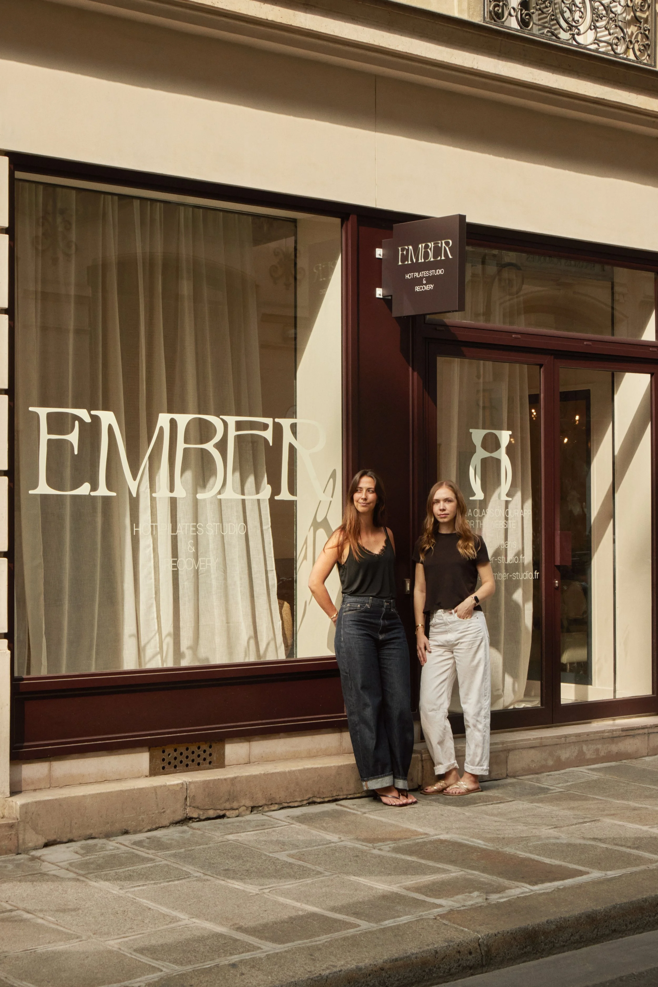 Les fondatrices devant Ember Studio à Paris, un lieu wellness rénové par Local Club avec façade, vitrophanie, enseigne et expérience client globale.