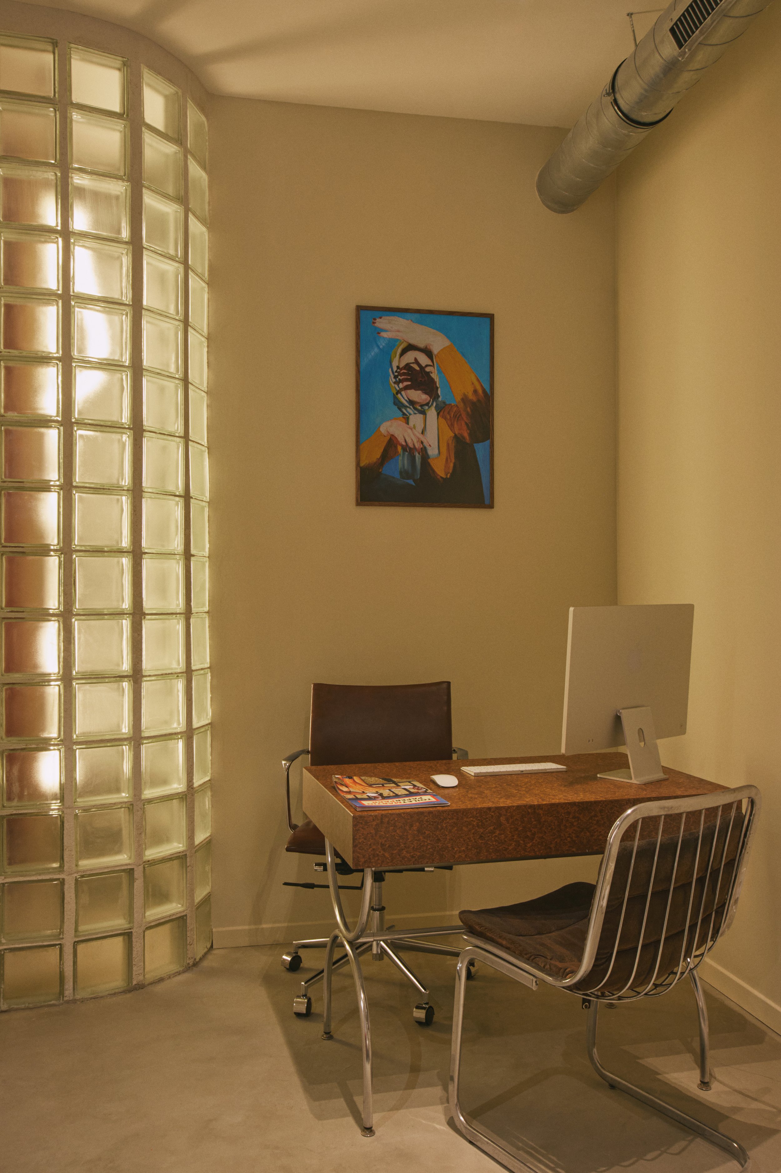 Espace de consultation dans un centre de détatouage laser à Marseille conçu par Local Club. Architecture intérieure sobre et chaleureuse, intégrant mobilier vintage, lumière douce et paroi en verre pour préserver l’intimité.