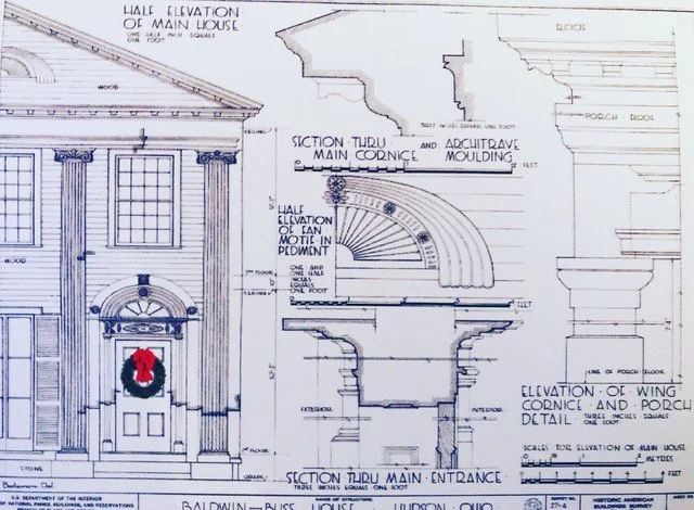 Architectural drawings of a classical building facade, including main elevation, pediment, cornice, and moldings, with detailed sections and measurements. A Christmas wreath is featured on the front door.