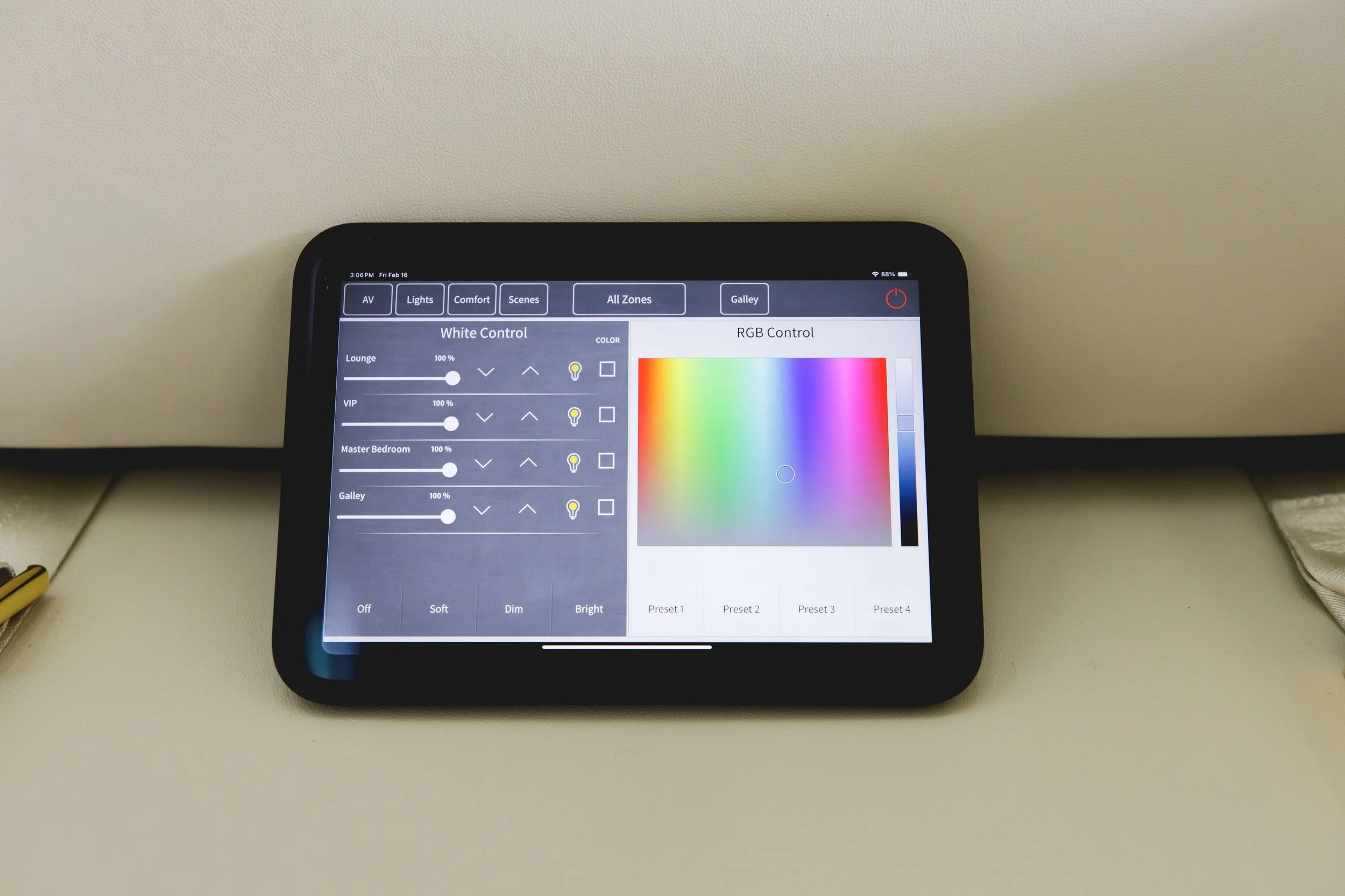 A tablet on a beige surface displaying a smart lighting control app with options for white and RGB lighting.