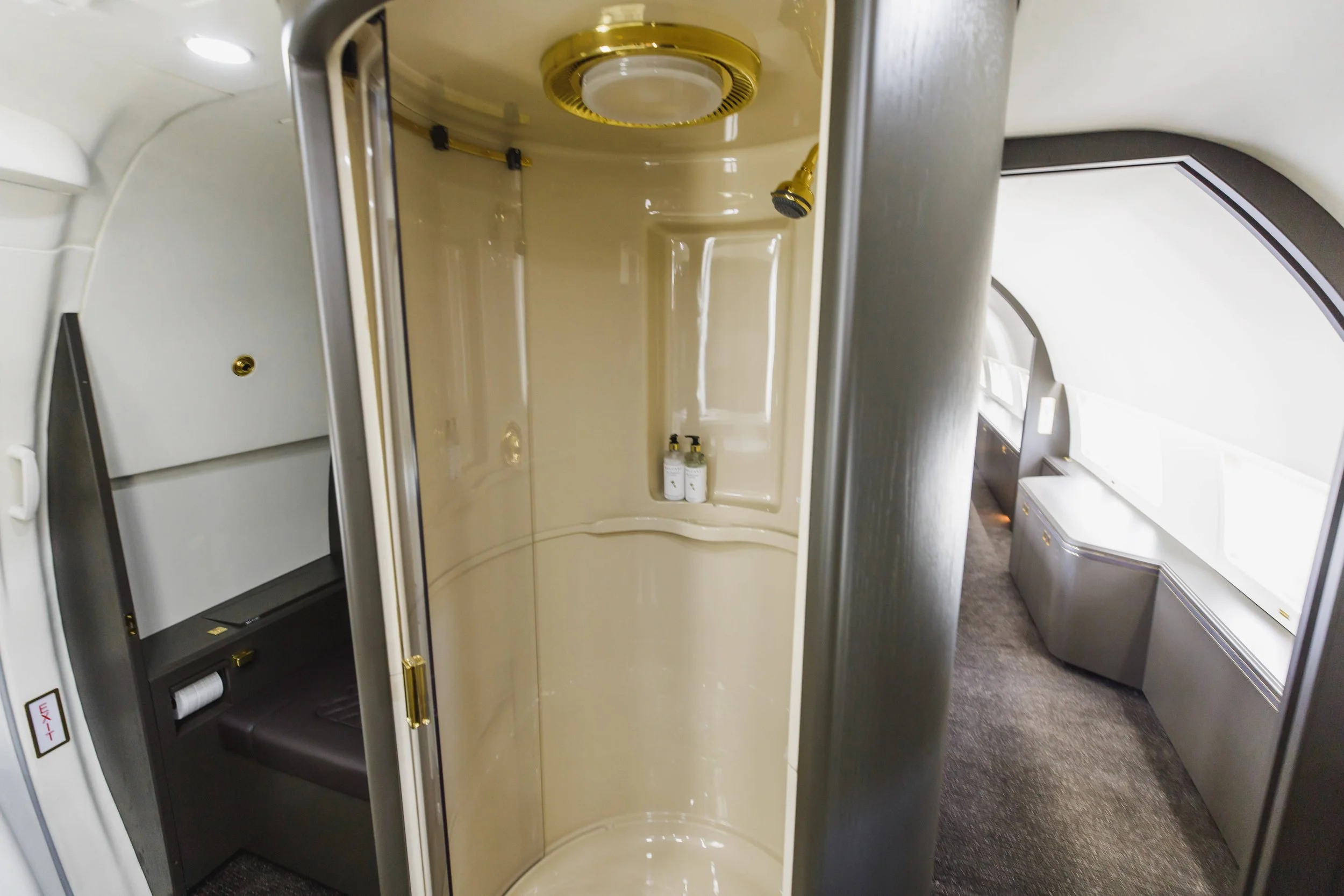First class airplane bathroom with shower and window view.