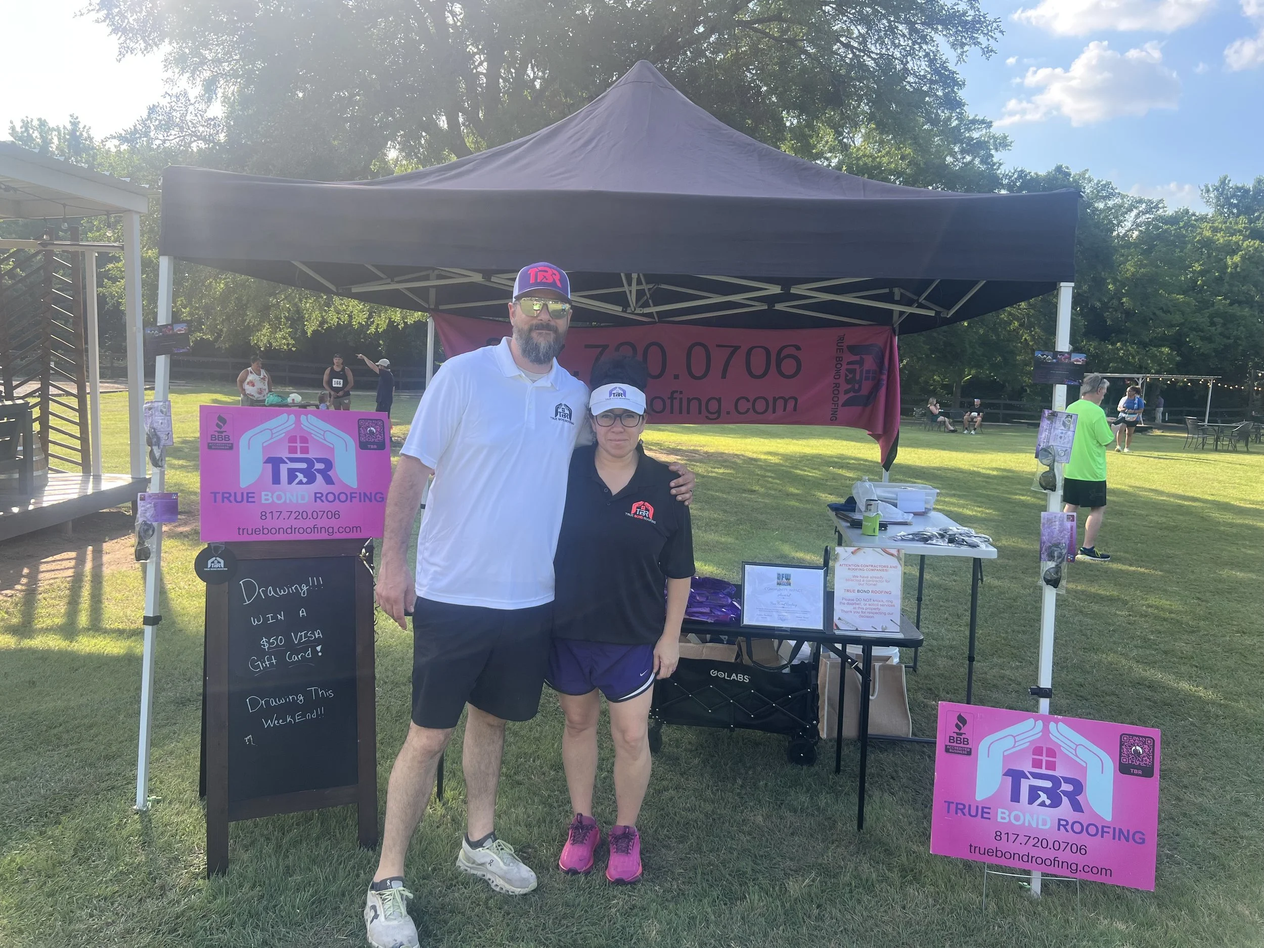 Aaron and Tiffany Lemons, owners of True Bond Roofing, at their community event booth in Grand Prairie.