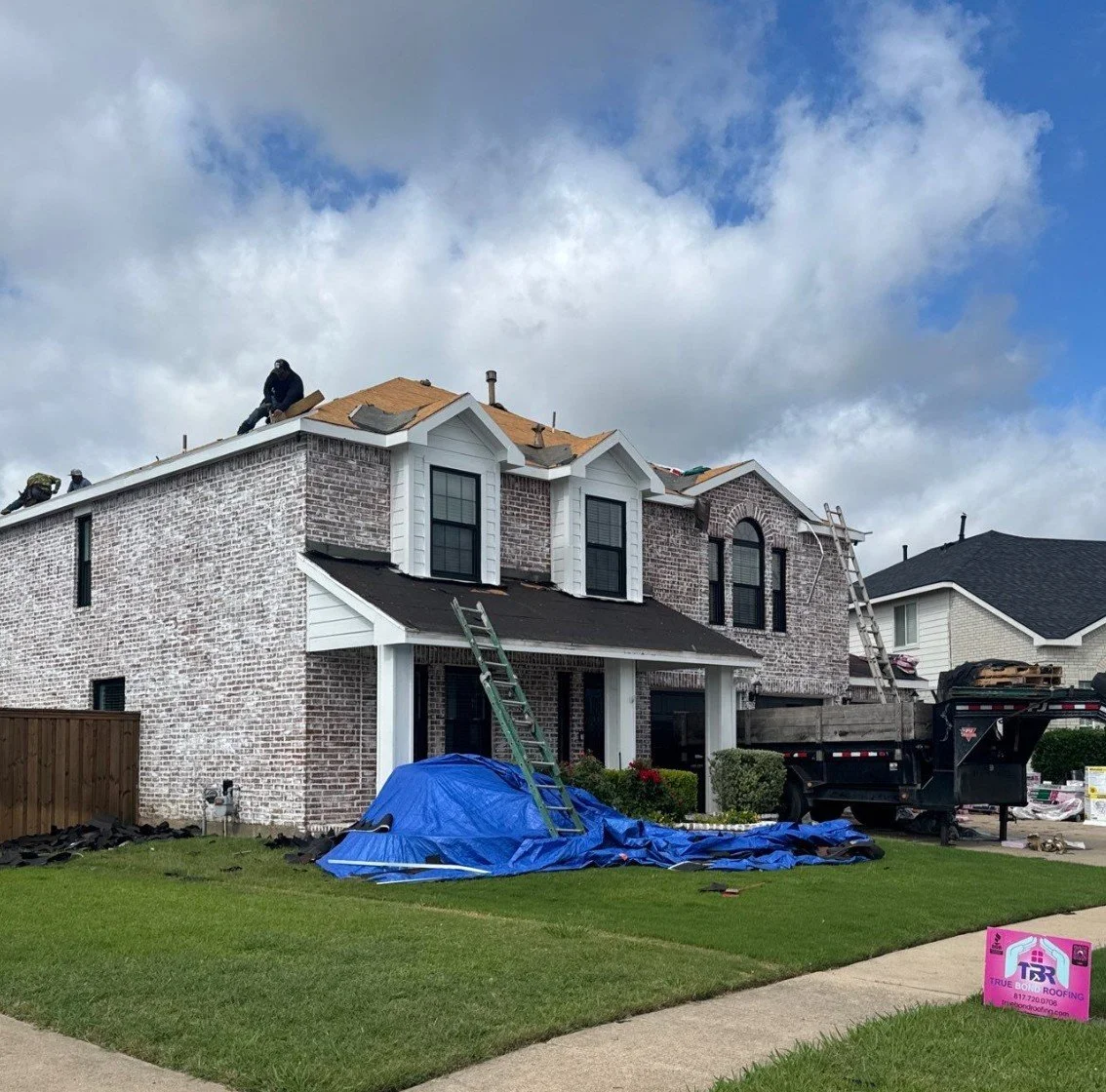 True Bond Roofing crew replacing the roof of a two-story brick home in Arlington, TX.