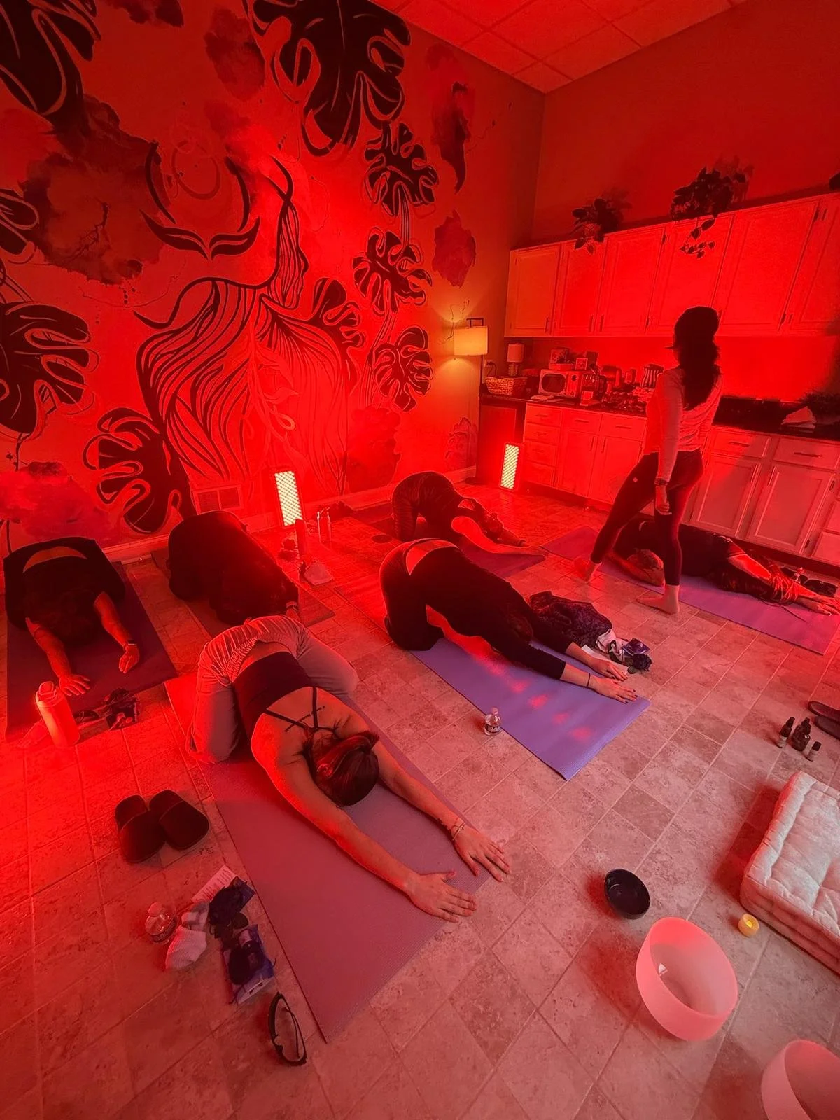 Group of women practicing yoga under infrared light at Aluma Wellness Studio in Chicago