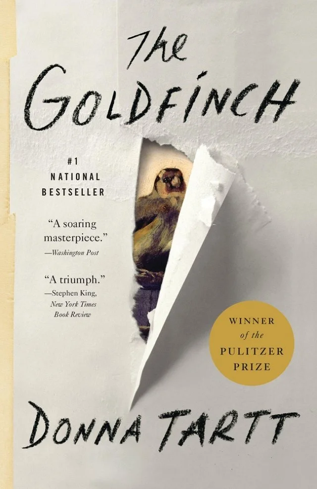 Book cover of The Goldfinch by Donna Tartt, showing a small bird peeking through torn paper, Pulitzer Prize seal visible.