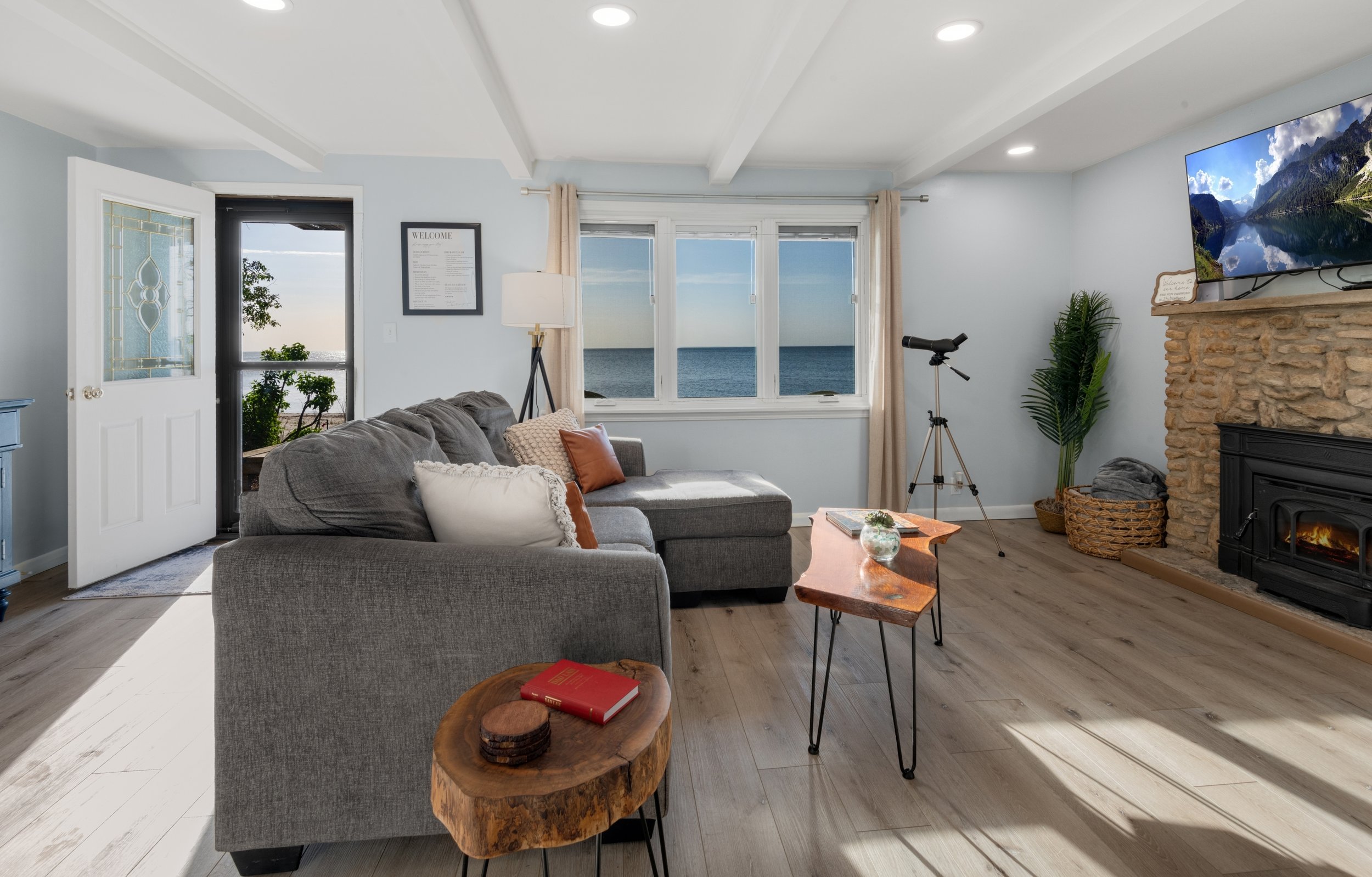 Open concept living room space with views of the water - include an indoor natural fireplace.