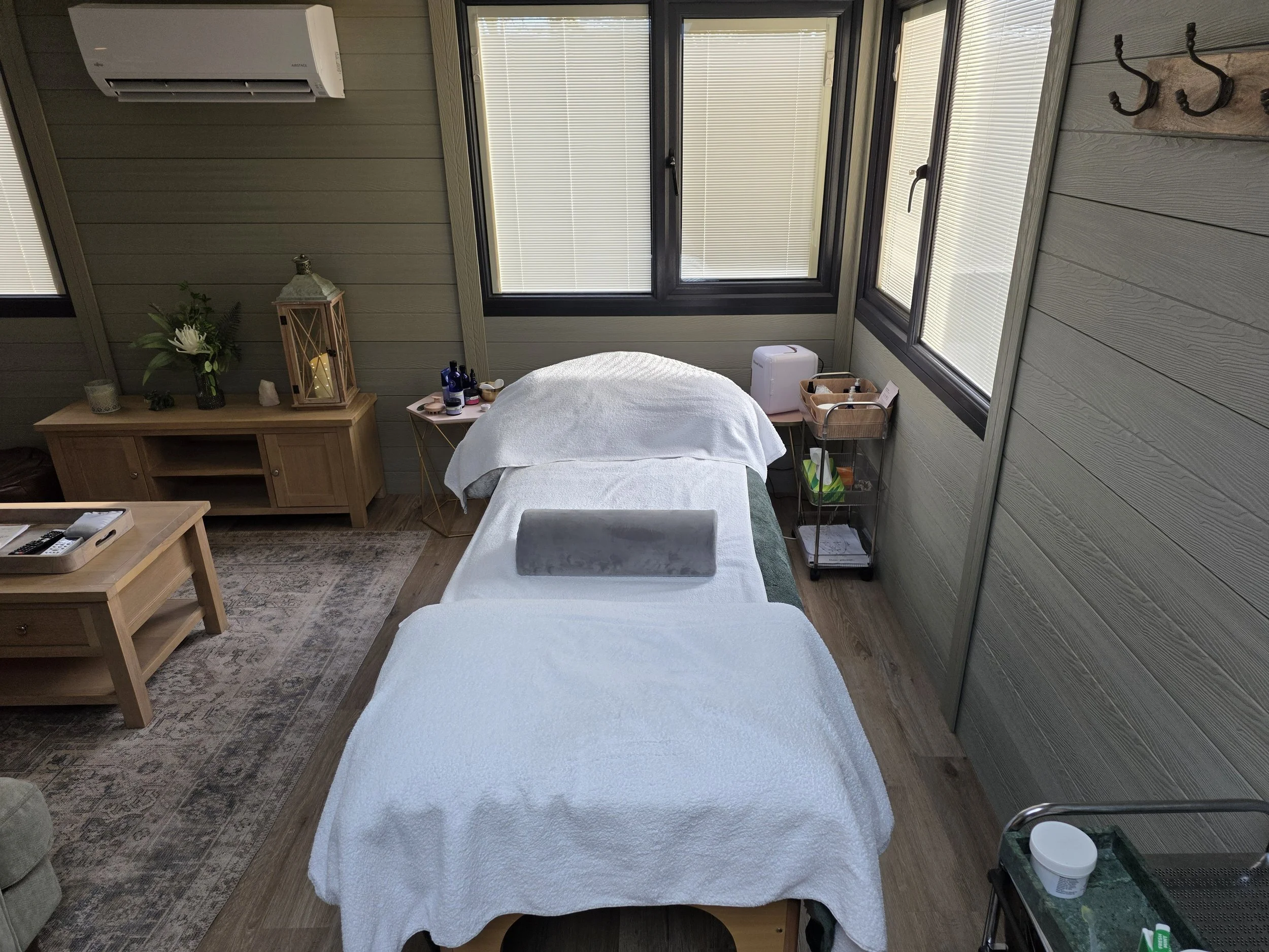 Decorative candle holder with intricate floral design, lit candle inside, placed on a wooden tray with leaf engravings.