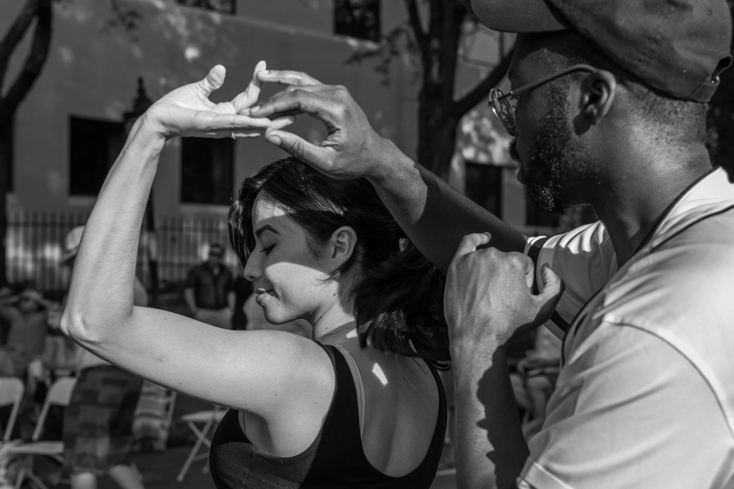 Two dancers at a Covington festival fully immersed in their dance, captured with a 35mm lens, illustrating connection and emotion.