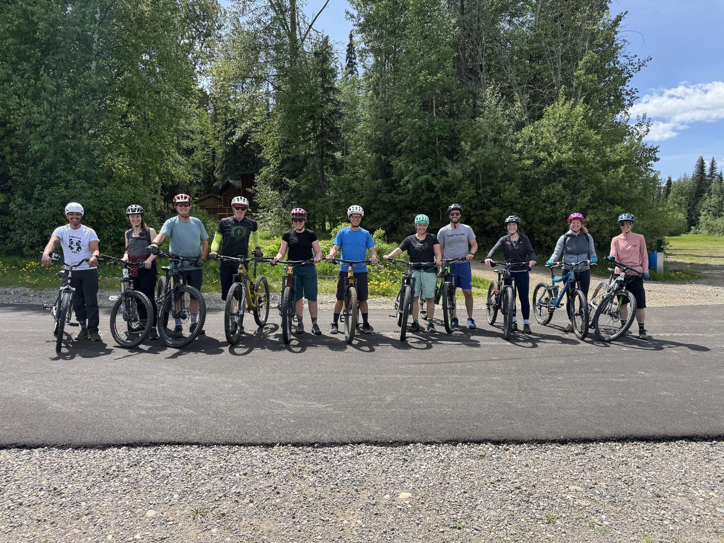 A group of people lines up with mountain bikes