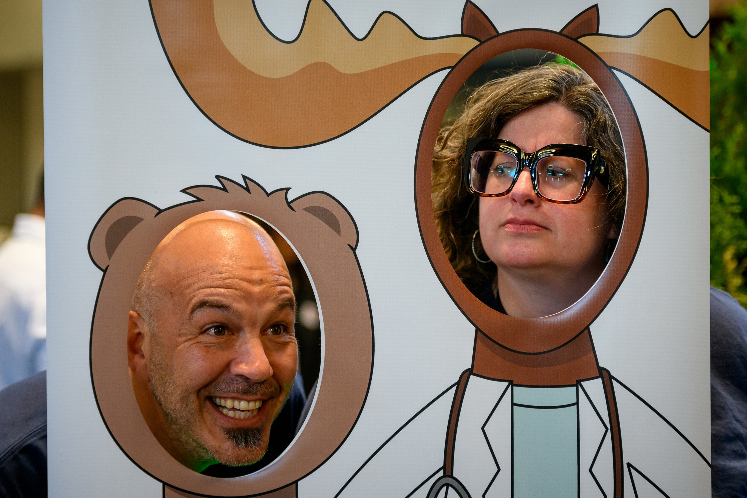 A group of three people in conversation, holding beverages and small plates of food.