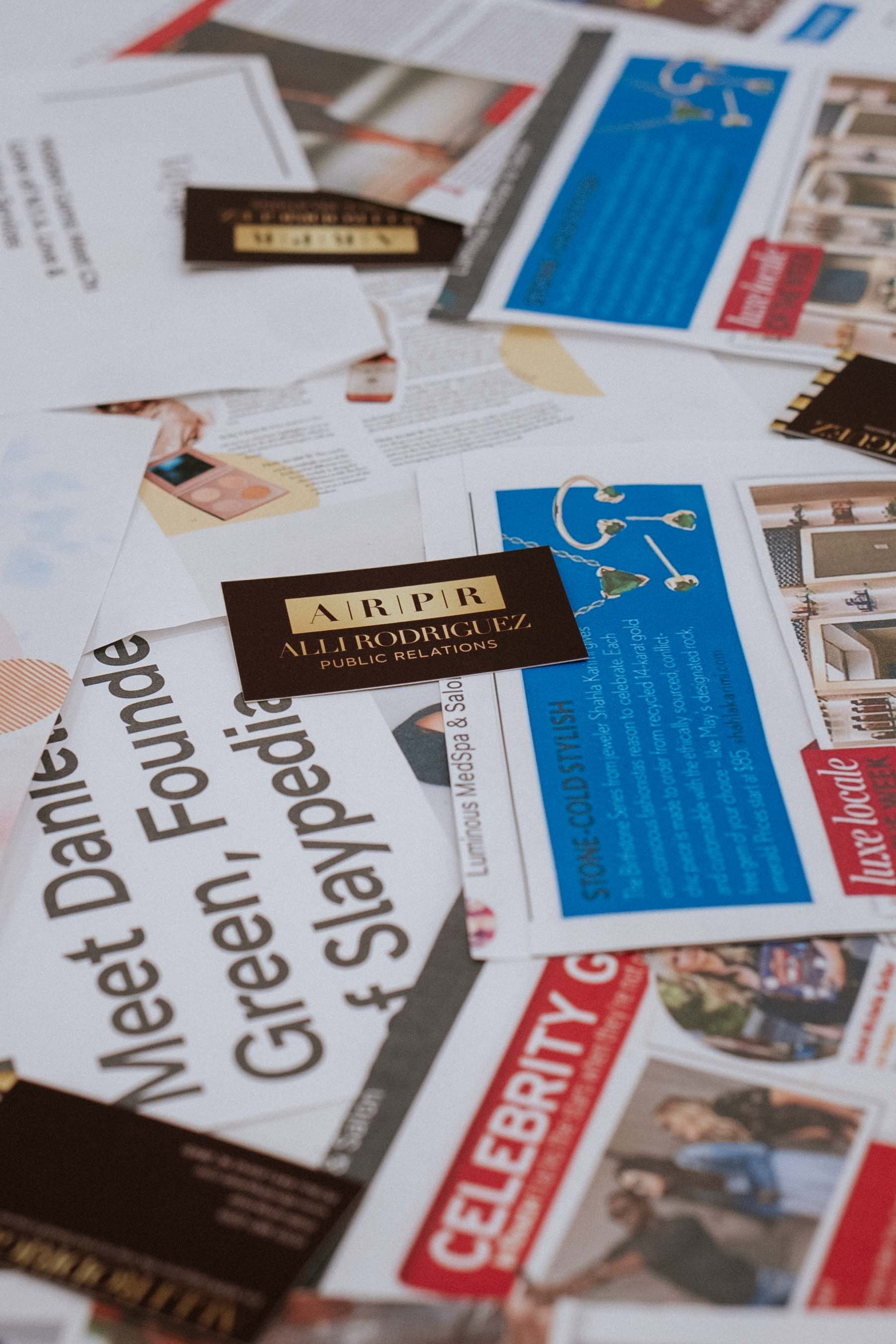Scattered business cards and magazine articles on a table.