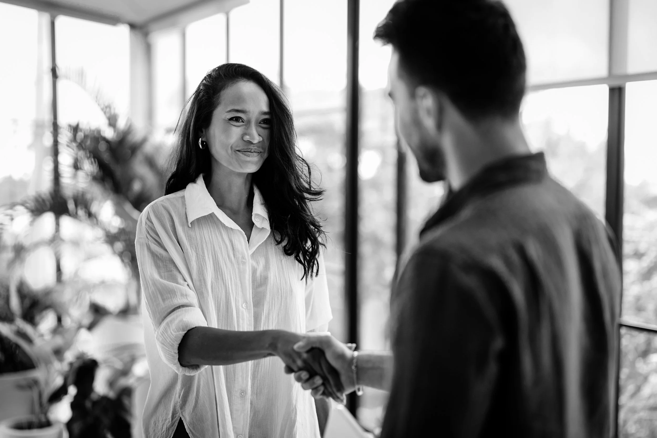 Dos personas en una oficina se están dando la mano en un apretón de manos.