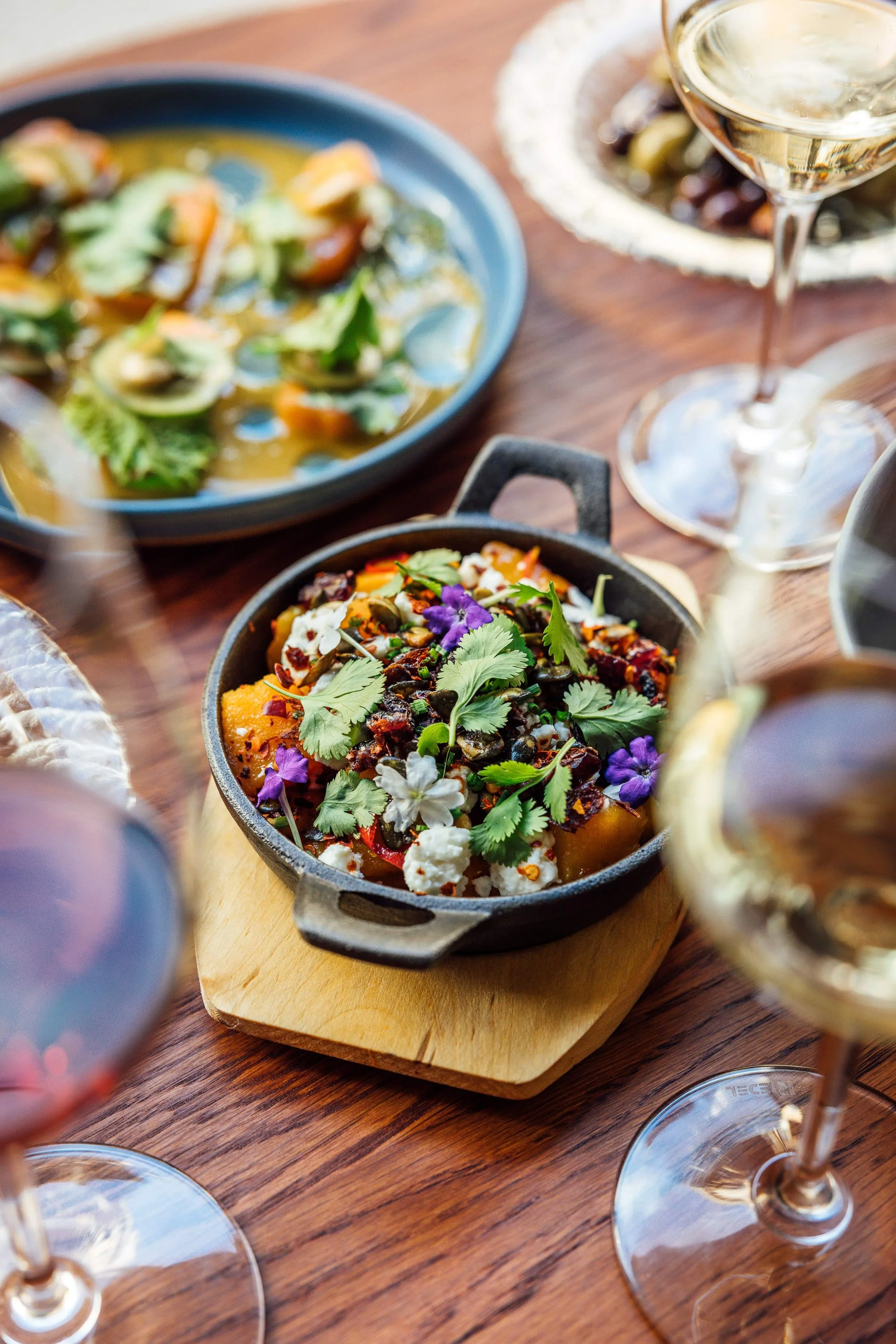 Dining table with seasonal dishes and white wine at restaurant Helsinki