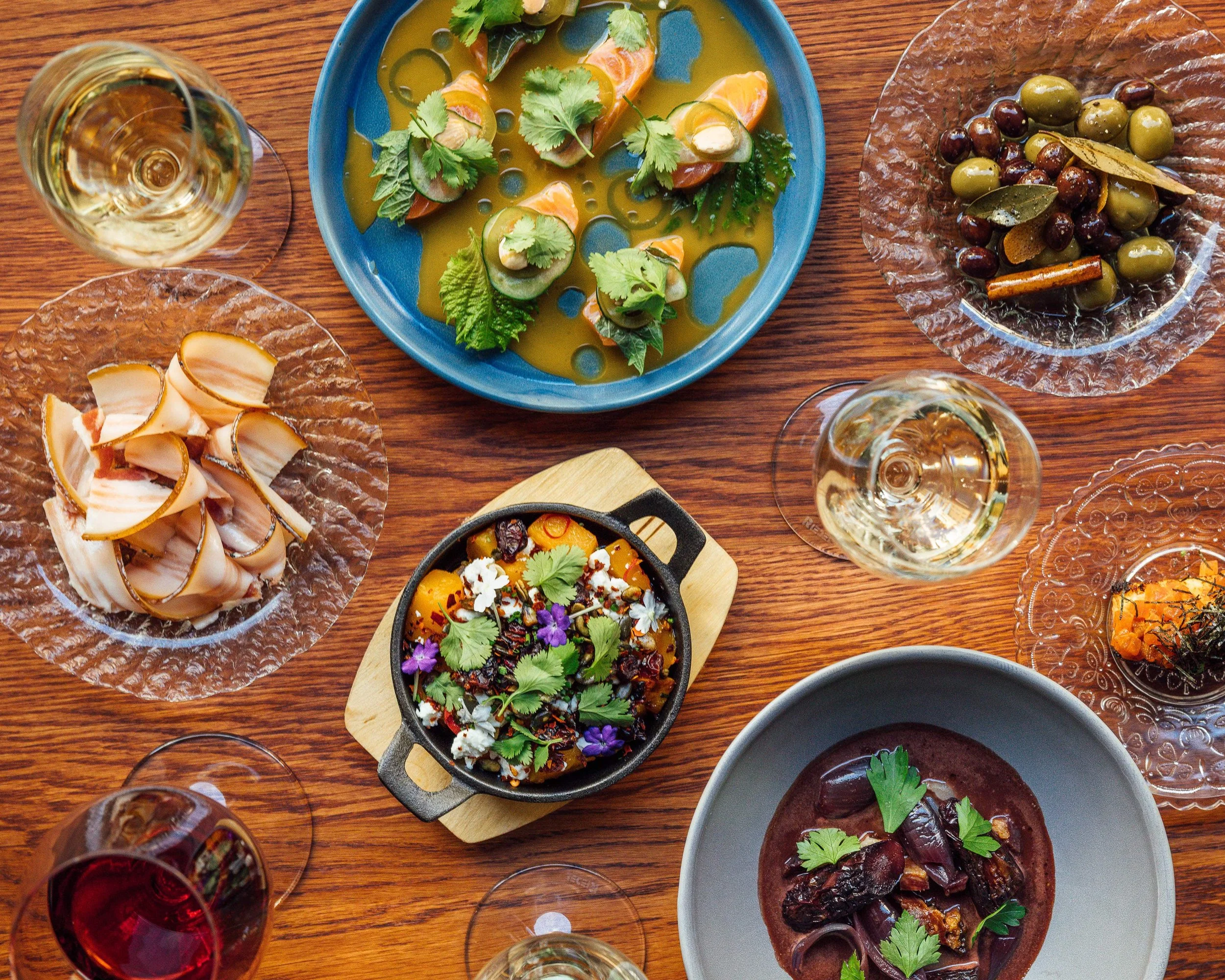 Shared plates with vegetables and wine at Helsinki restaurant