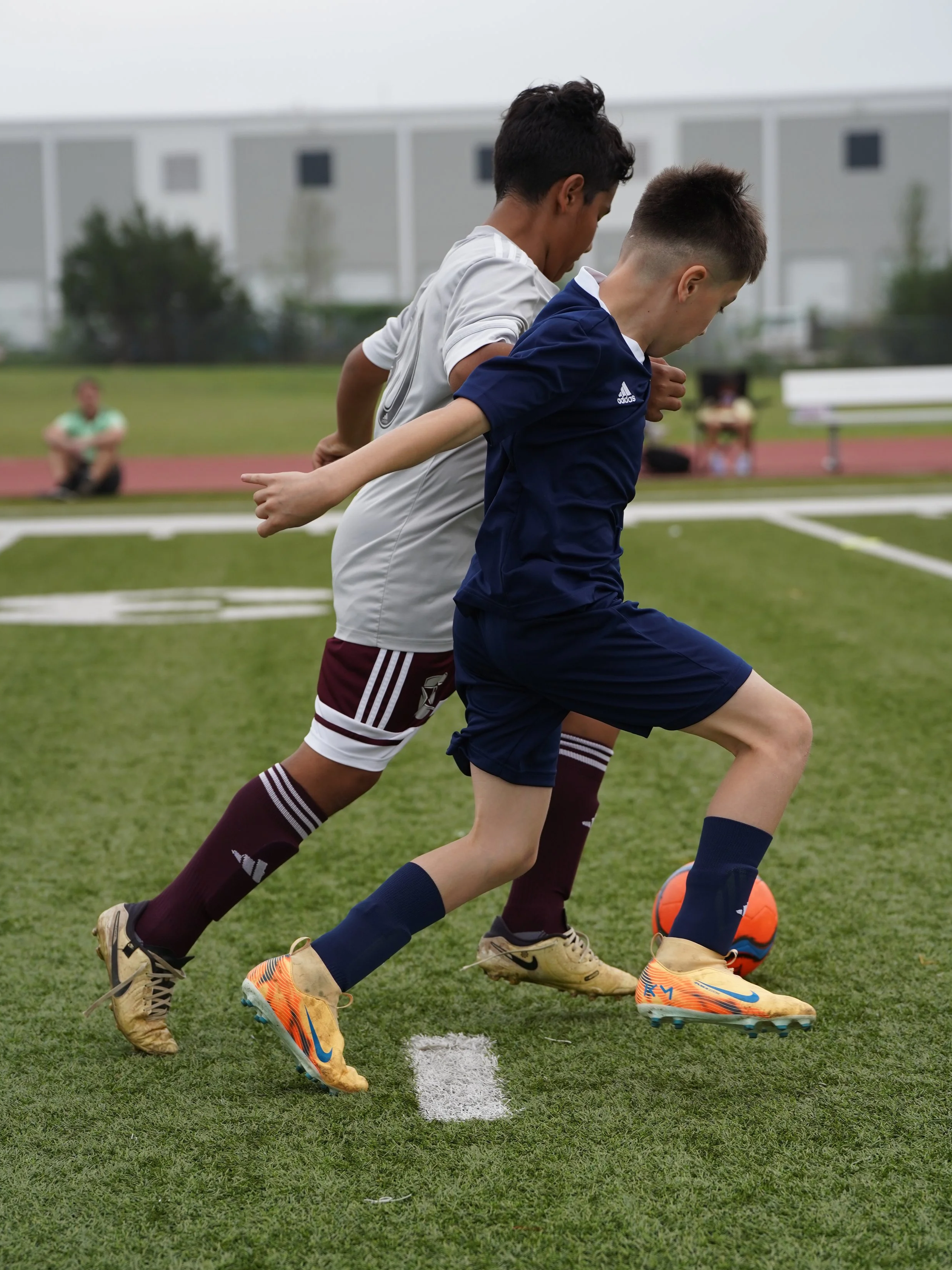Youth soccer training session with children and coaches on a grassy field.