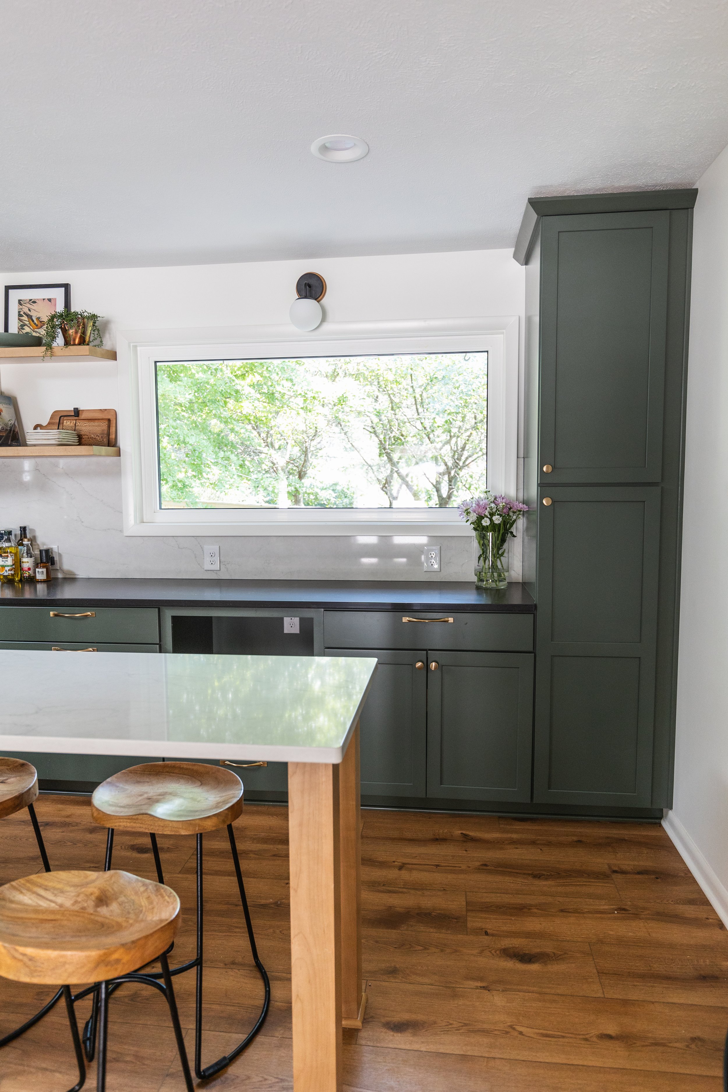 1962 Kitchen Remodel, dark green cabinets, white quartz island, wooden floors, brass hardware, wood cabinets, custom hood, floating shelves, dark countertops, open shelving