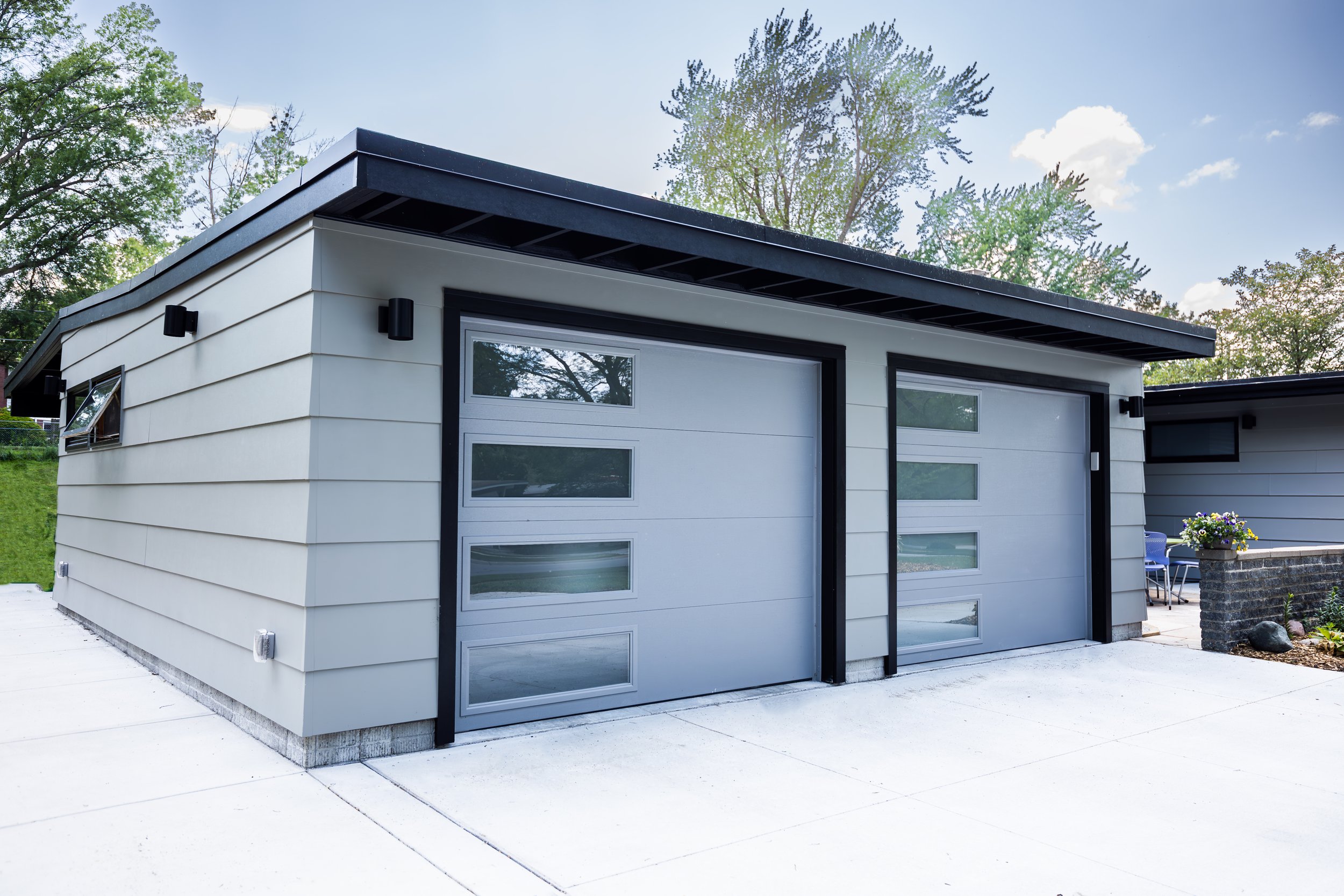1956 Carport to Garage Transformation, Lincoln Nebraska, professional contractors, craftsmanship, matte black sconces, mid century modern design, gray garage door