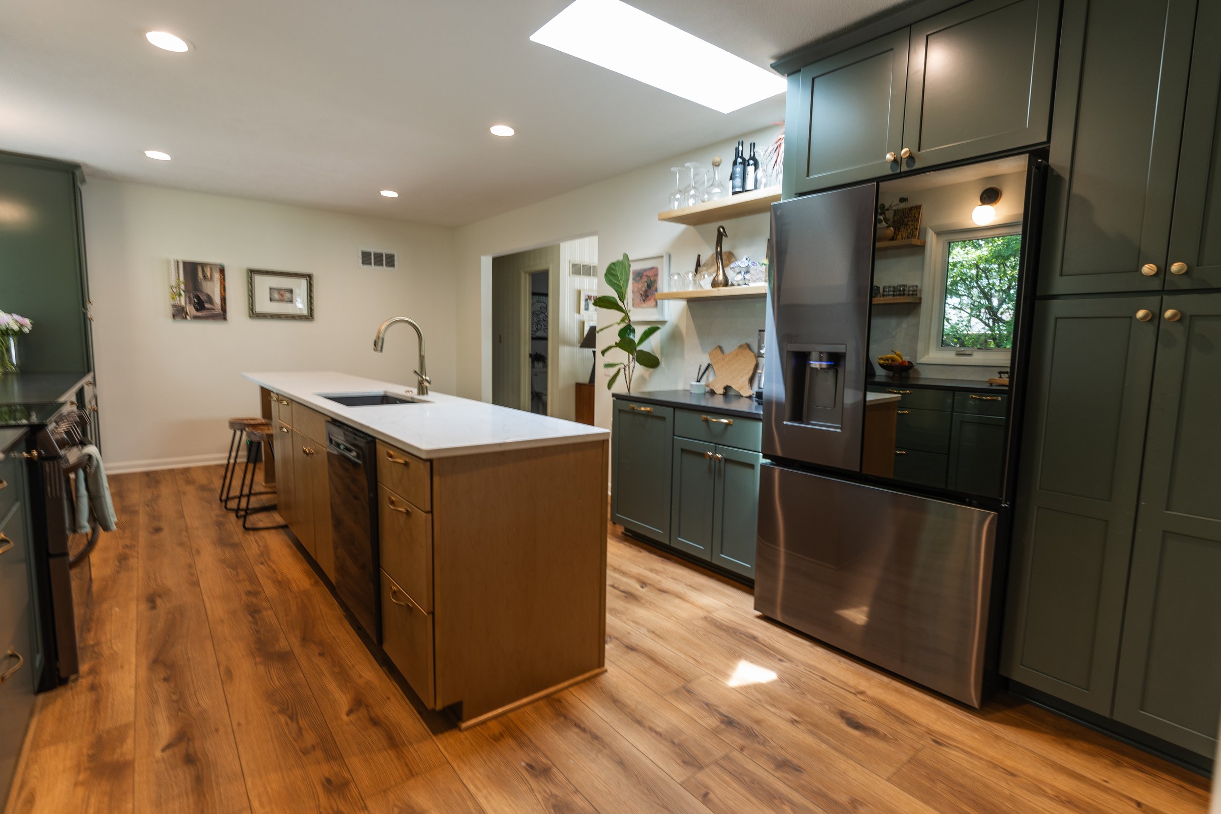 1962 Kitchen Remodel, dark green cabinets, white quartz island, wooden floors, brass hardware, wood cabinets, custom hood, floating shelves, dark countertops, open shelving