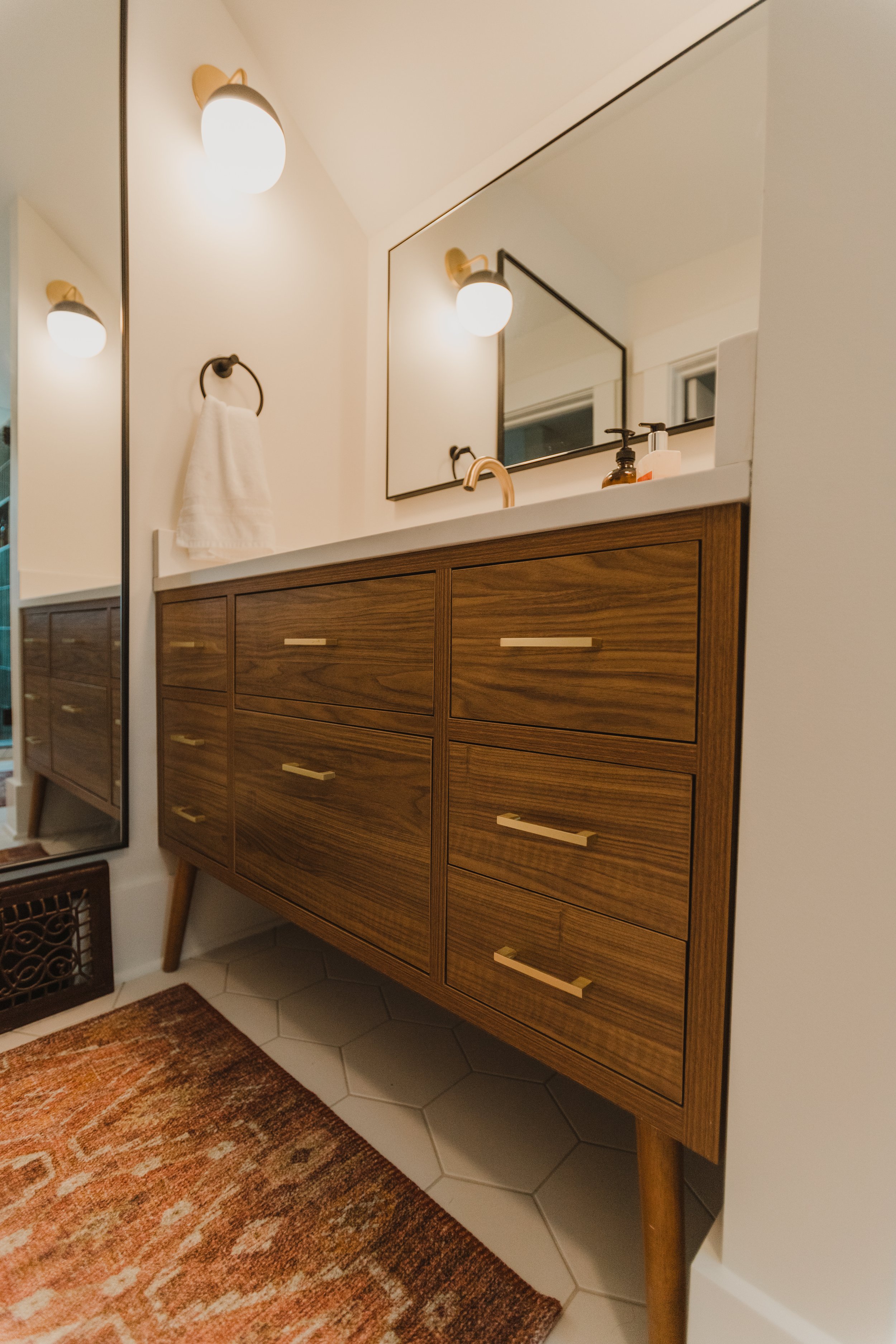 1920 Bathroom Remodel, custom wood vanity, brushed gold hardware, brushed gold sconces, modern design, mixed metal finishes, green subway tile, white hexagon floor tile, Lincoln Nebraska, professional contractors, remodeling and renovations.