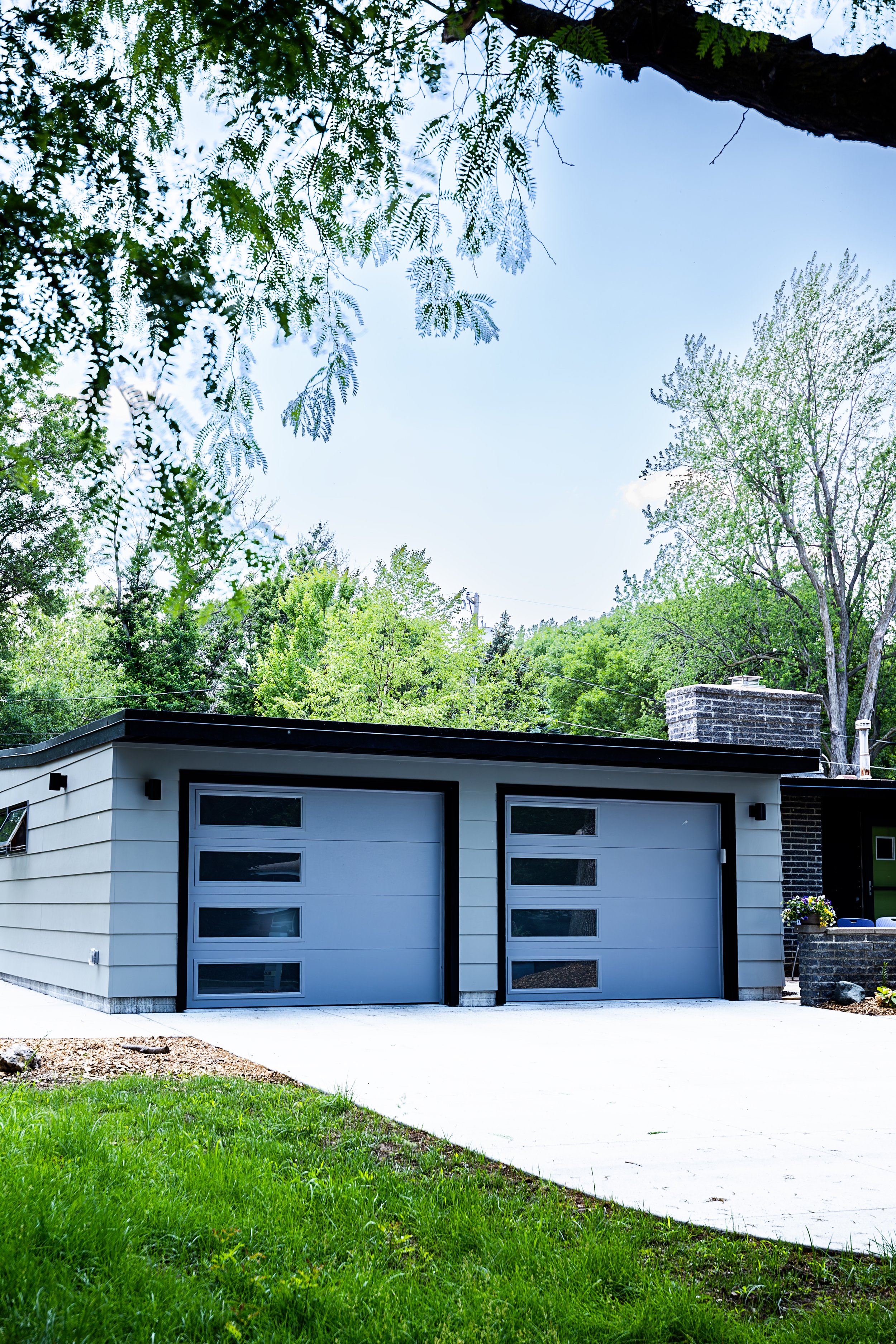 1956 Carport to Garage Transformation, Lincoln Nebraska, professional contractors, craftsmanship, matte black sconces, mid century modern design, gray garage door