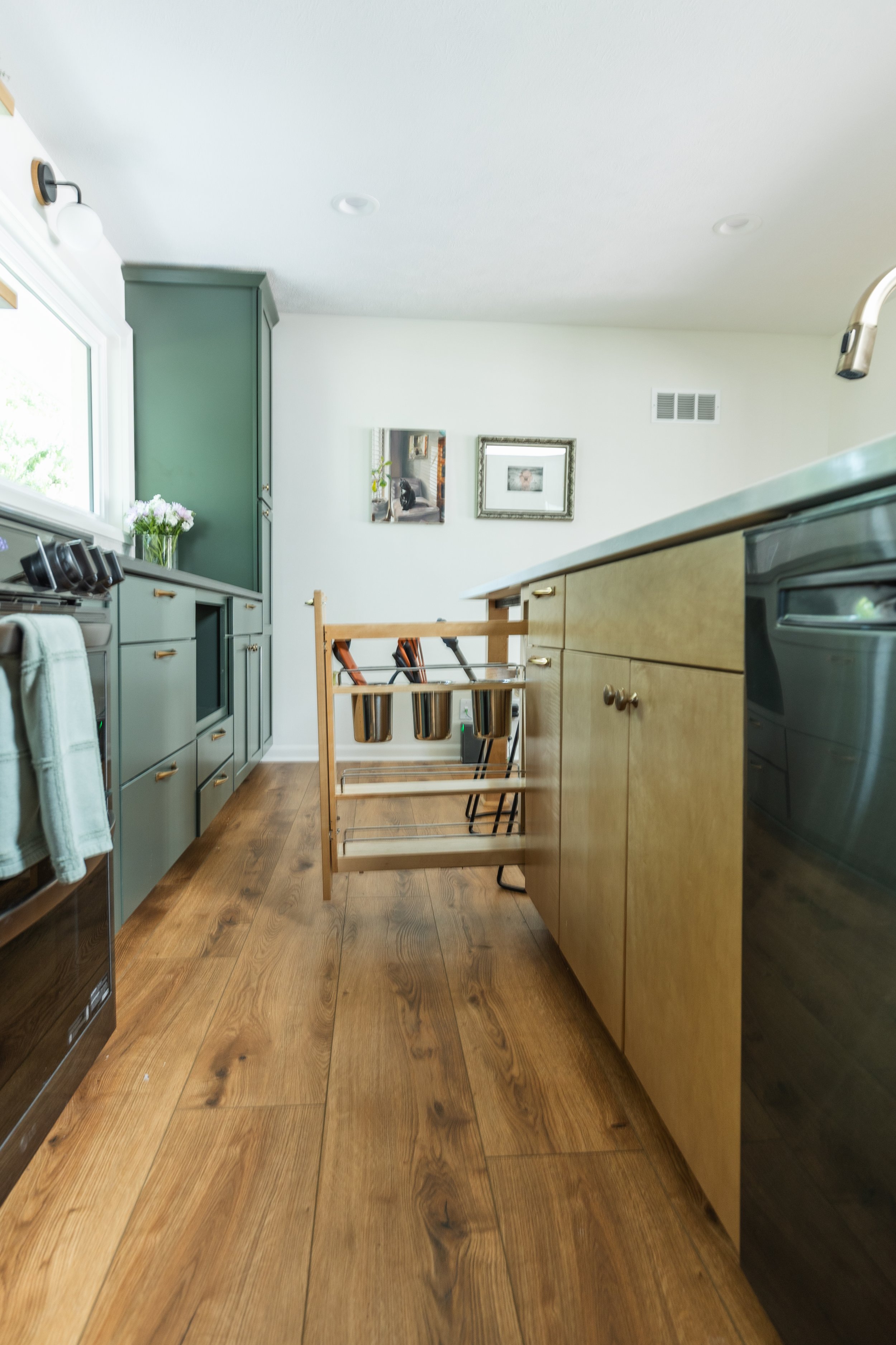 1962 Kitchen Remodel, dark green cabinets, white quartz island, wooden floors, brass hardware, wood cabinets, custom hood, floating shelves, dark countertops, open shelving, large windows, craftsmanship, custom cabinets.