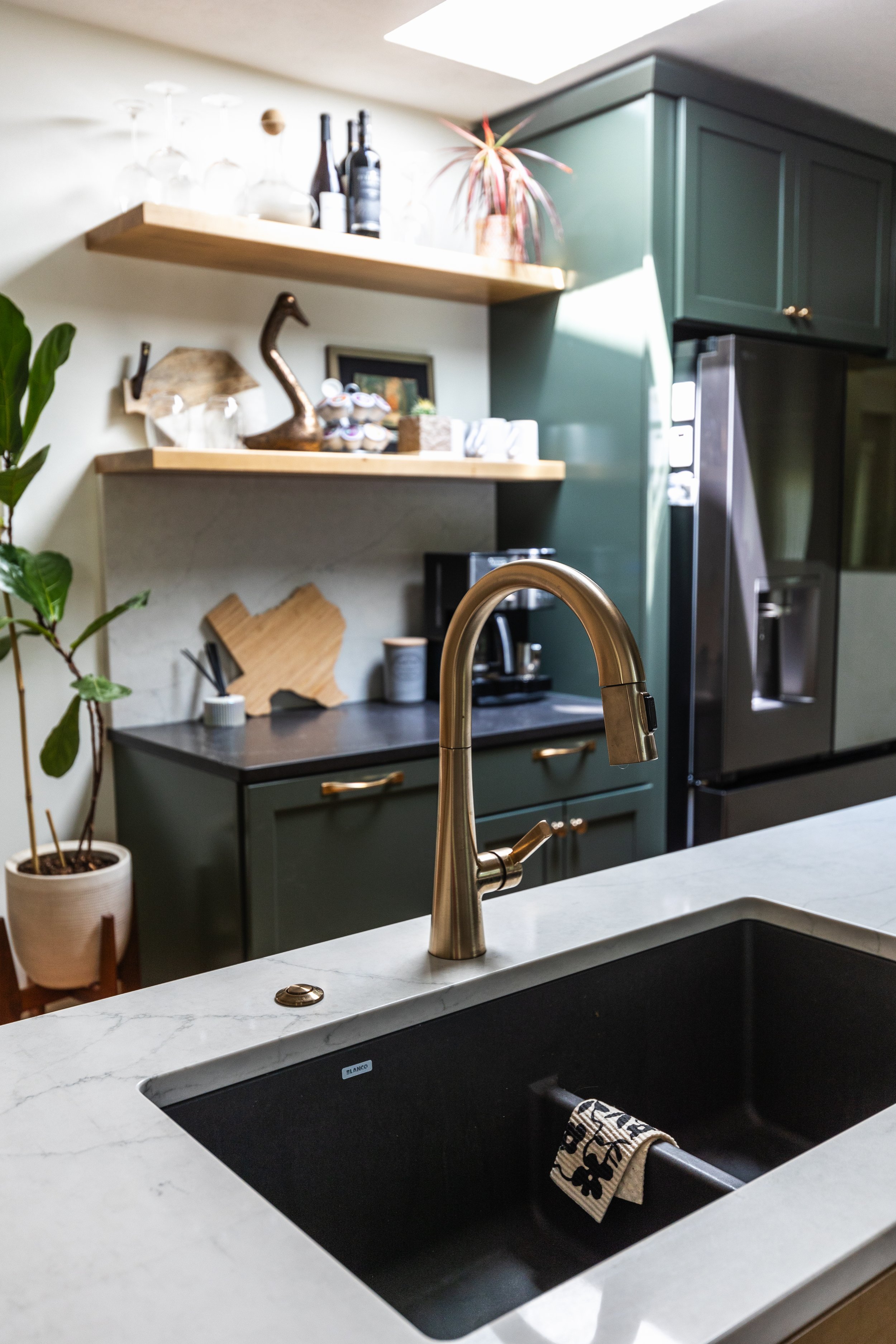 1962 Kitchen Remodel, dark green cabinets, white quartz island, wooden floors, brass hardware, wood cabinets, custom hood, floating shelves, dark countertops, open shelving, large windows, craftsmanship, custom cabinets.