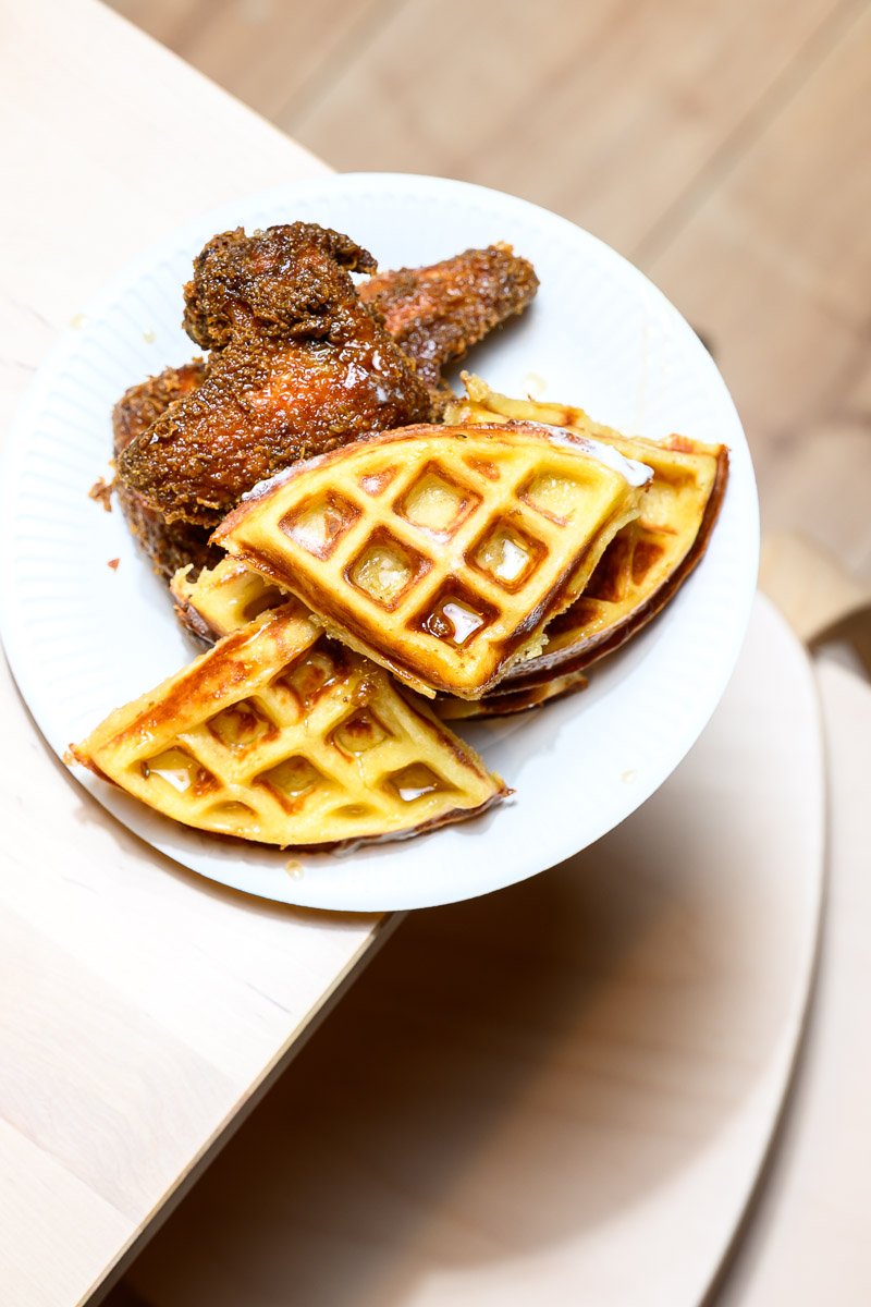 Plate with fried chicken and waffles on a white dish.