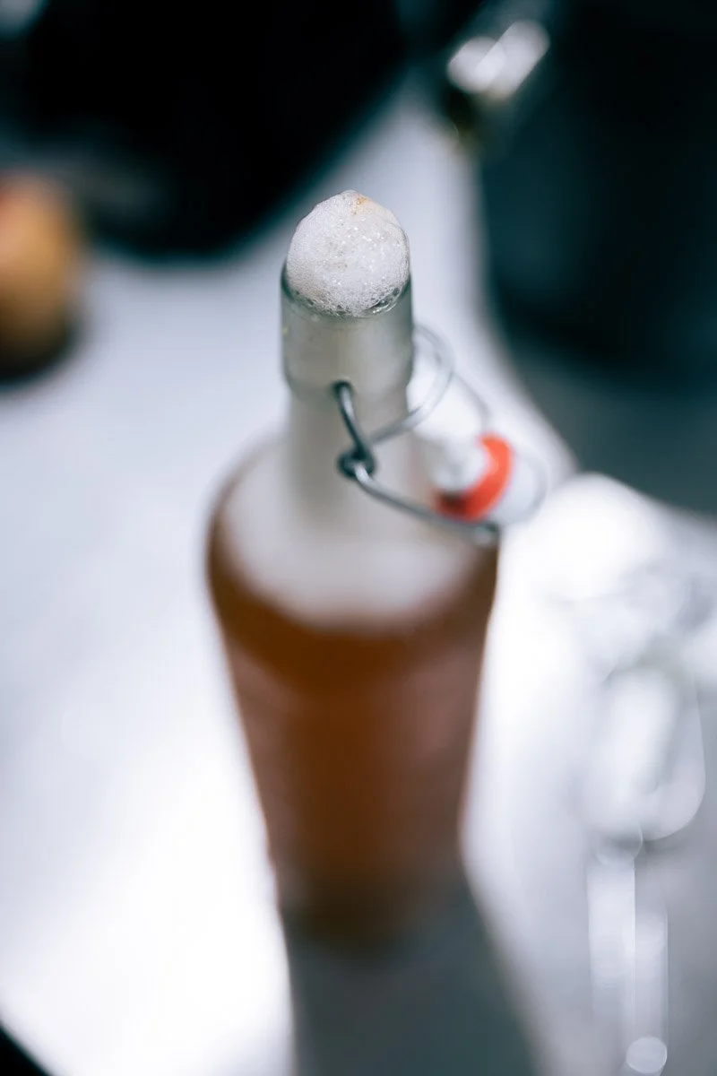 Close-up of a beer bottle with a foam-sealed bottle cap, viewed from above.