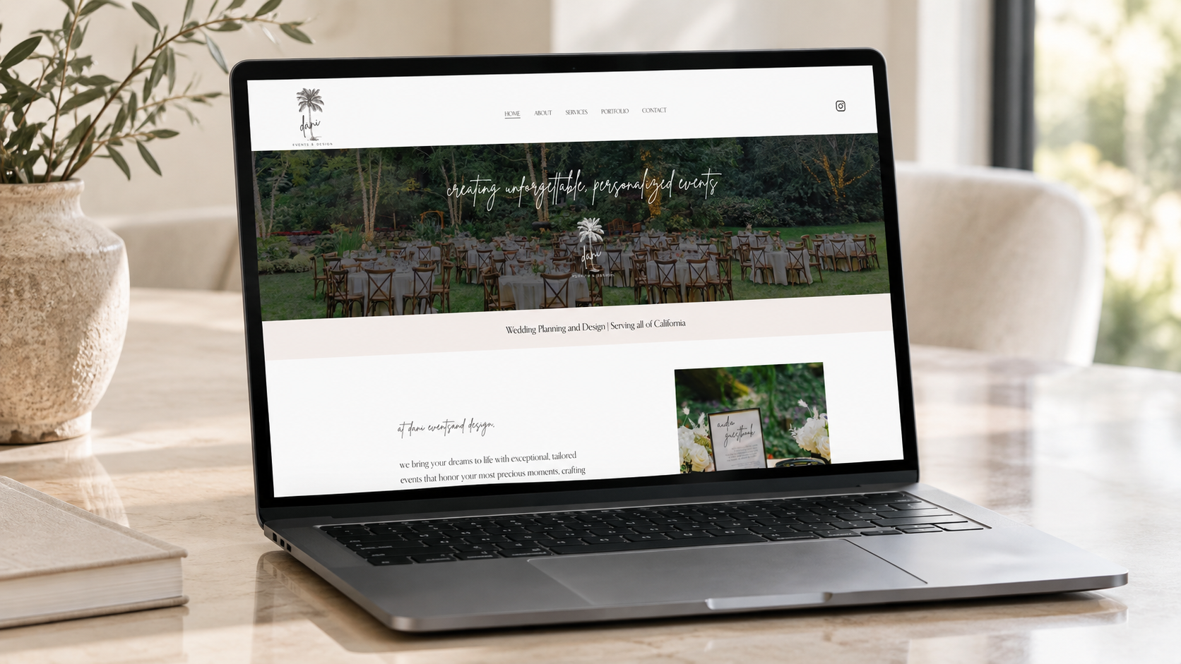 Laptop on a table displaying a website for wedding planning and design, featuring outdoor wedding setup with round tables and chairs in a garden.