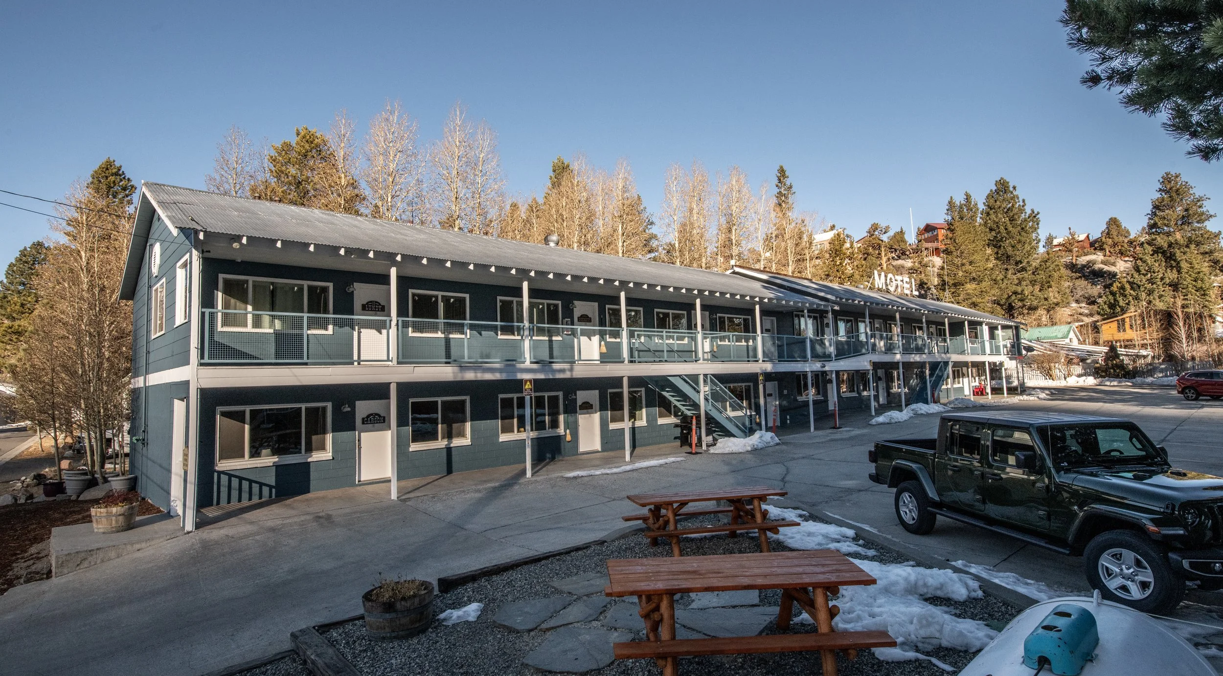 A view of the exterior of Gull Lake Lodge motel with treed background of June Lake, California