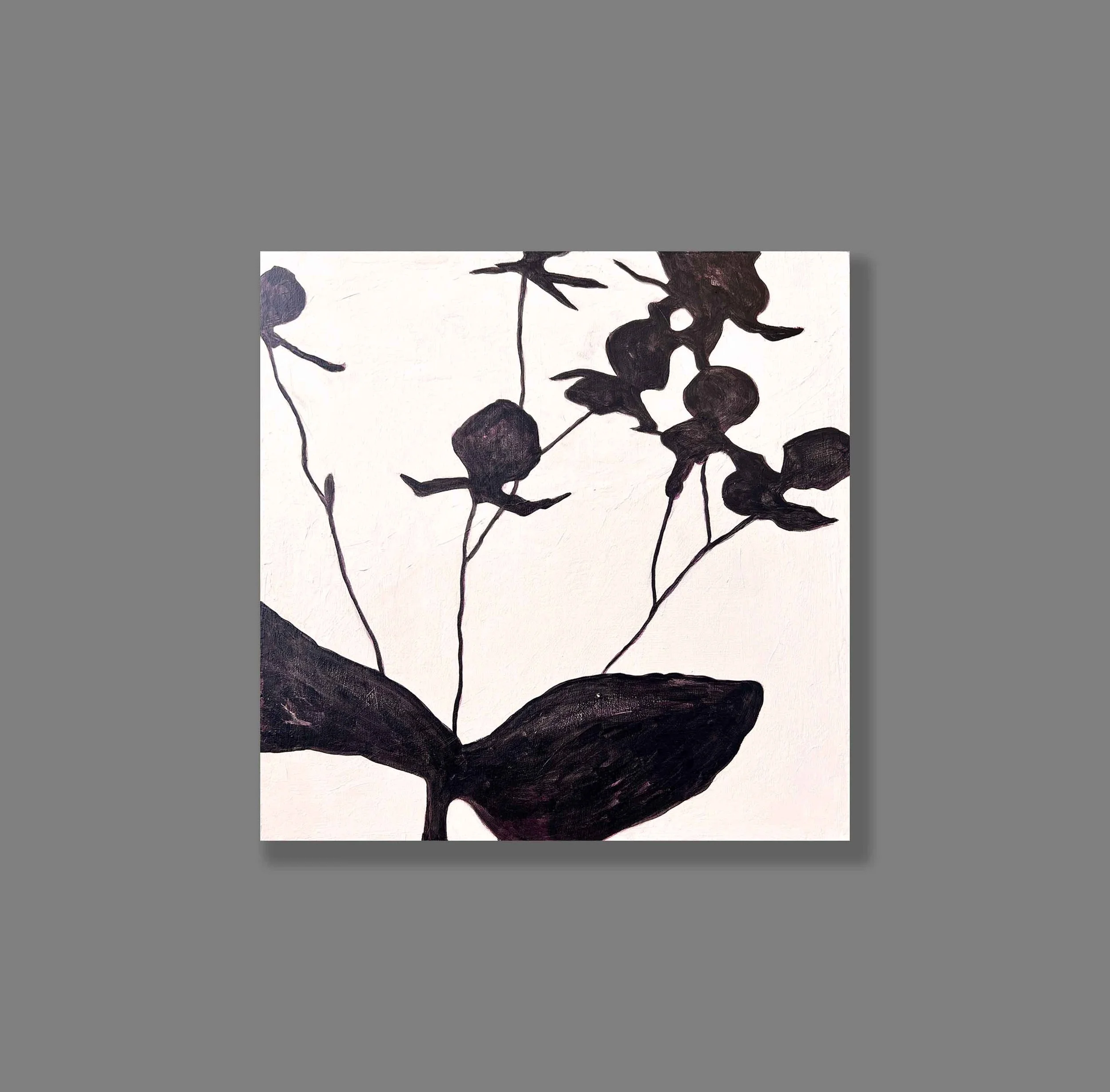 Black silhouette of a flower with leaves and buds on a light background, displayed against a gray backdrop.