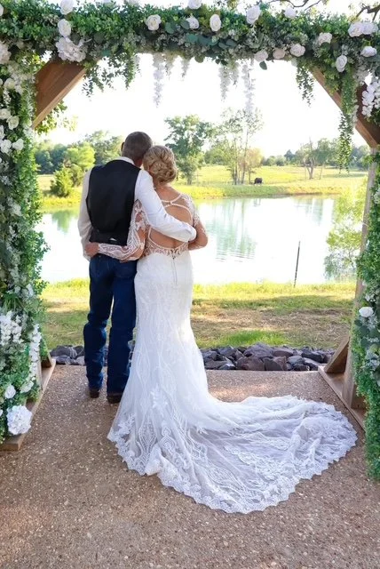 bride-groom-first-look-by-pond-arms-around-each-others-backs-and-hugging.JPG
