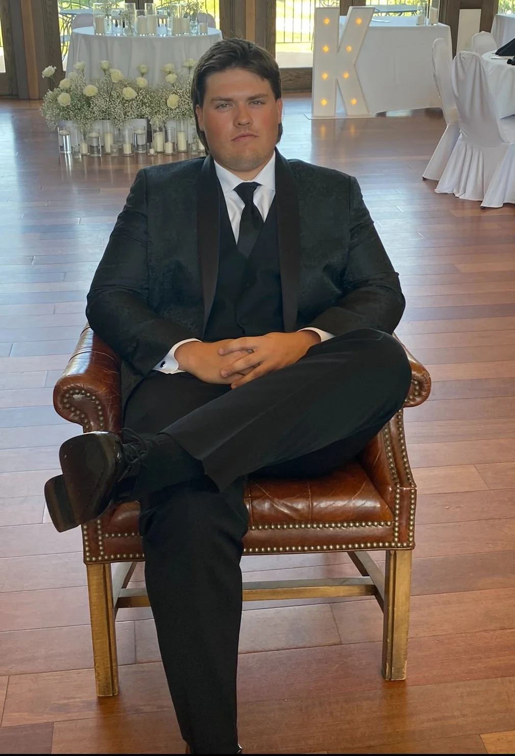 A groom sitting in a chair before the wedding ceremony.