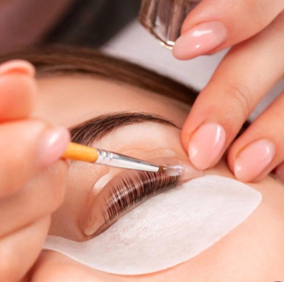 Close-up of eyelash extension application with brush and gel pad on eye