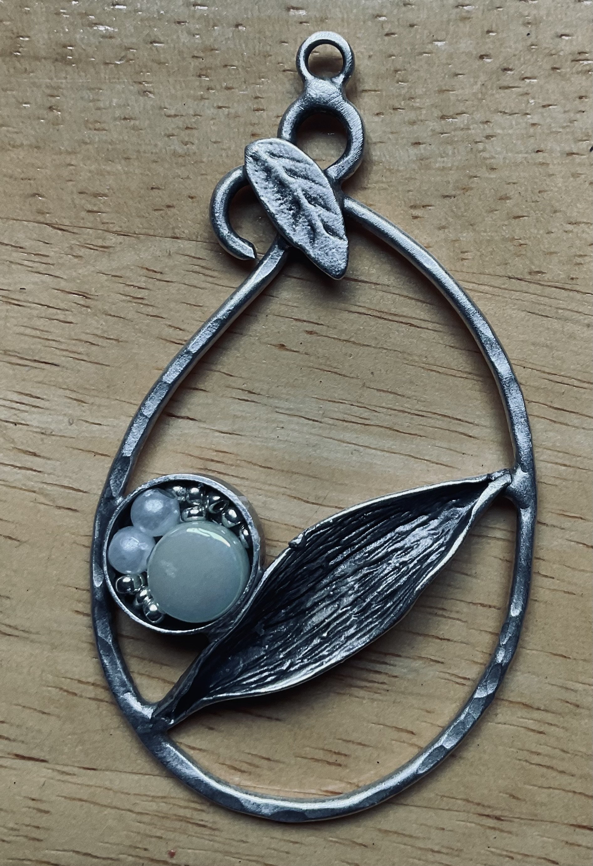 Silver coloured metal pendant 70mm long with a assorted stones