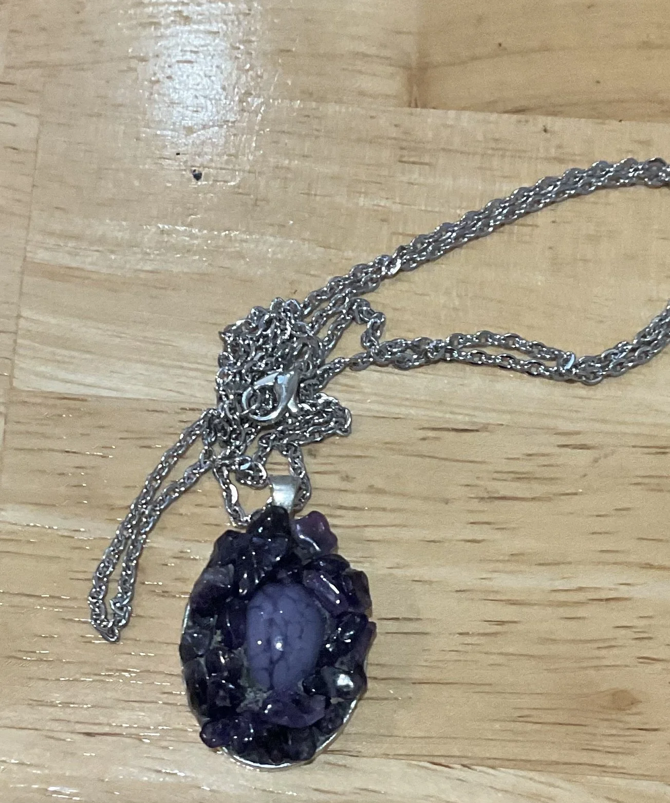 Silver plated pendant 45mm long filled with fused glass and amethyst chips.