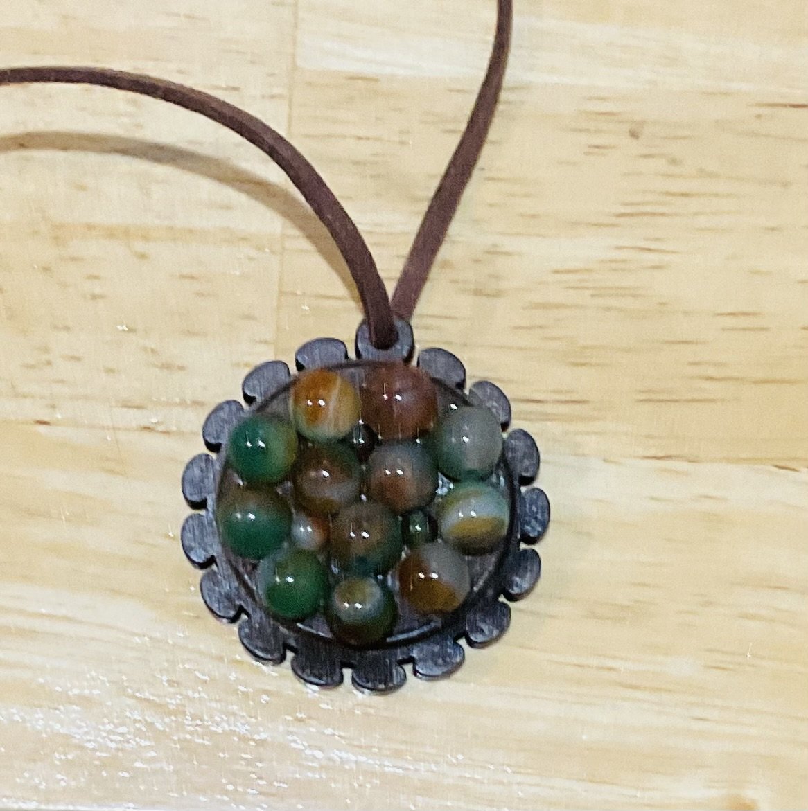 Wooden pendant 45mm filled with natural stone beads. For sale