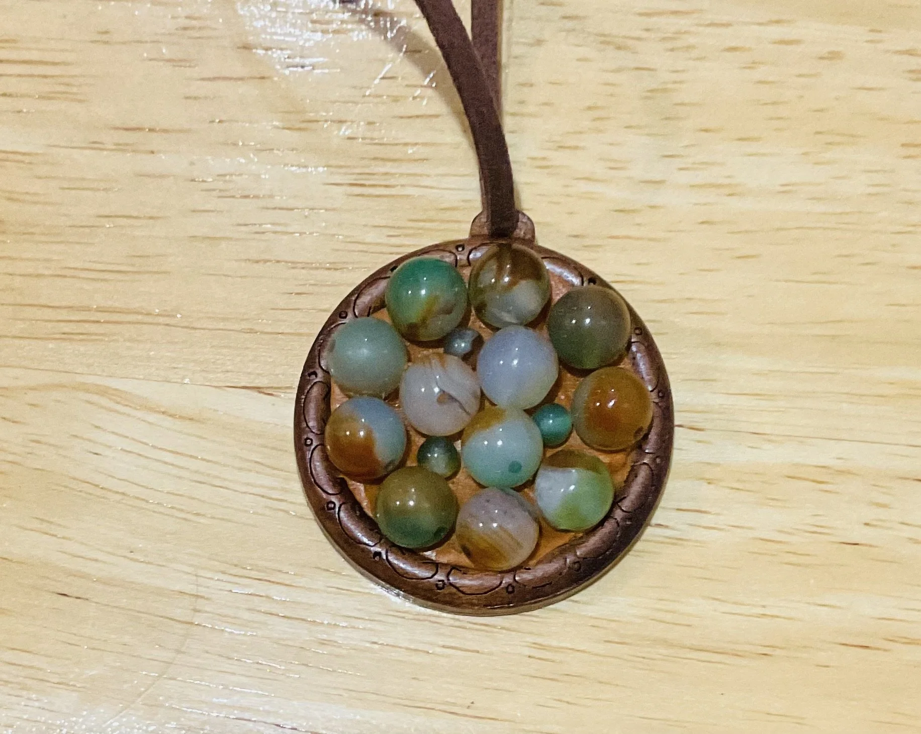 Wooden pendant 45mm filled with natural stone beads. For sale