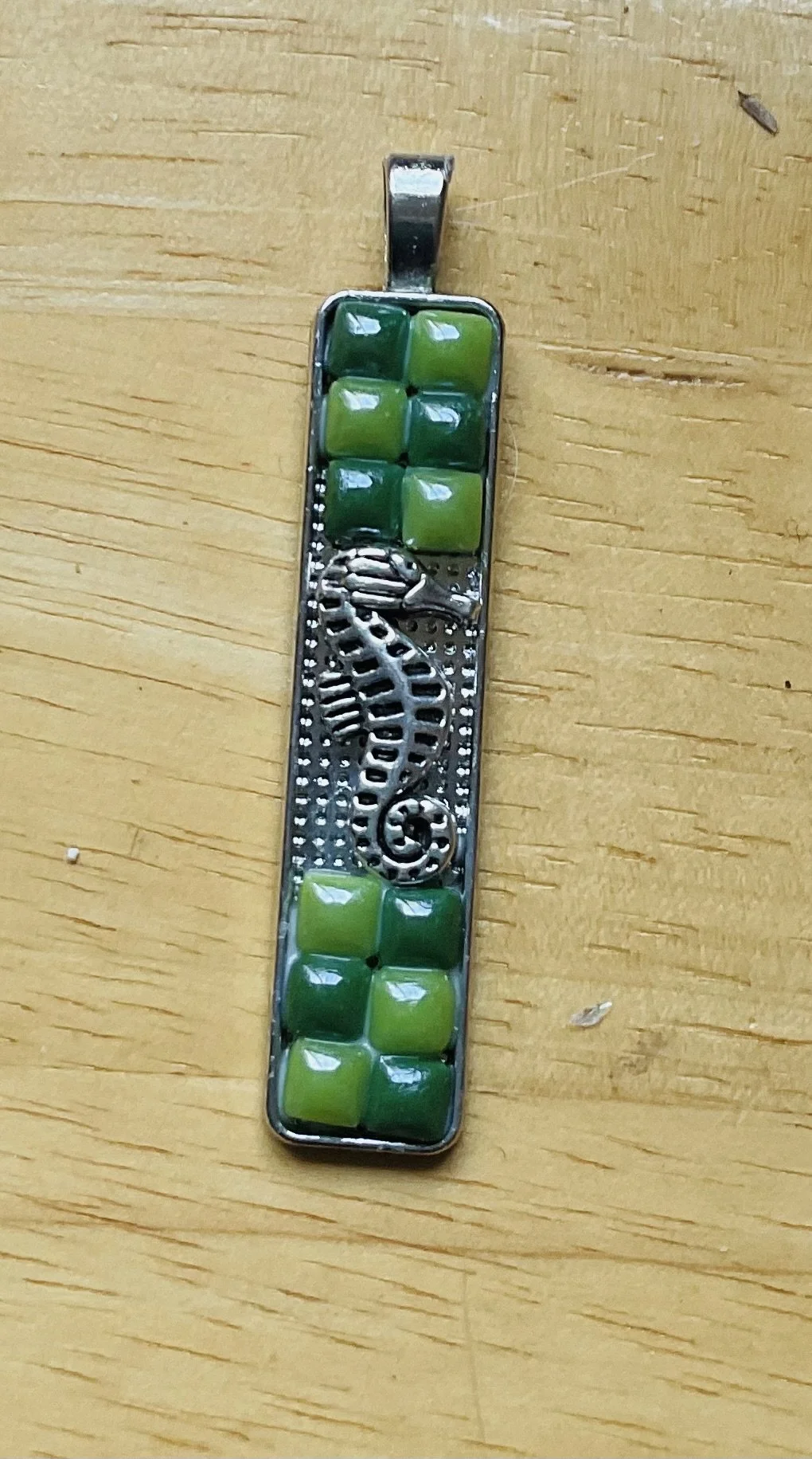 Silver plated pendant 50x10mm filled with a seahorse and tiny green ceramic tiles
