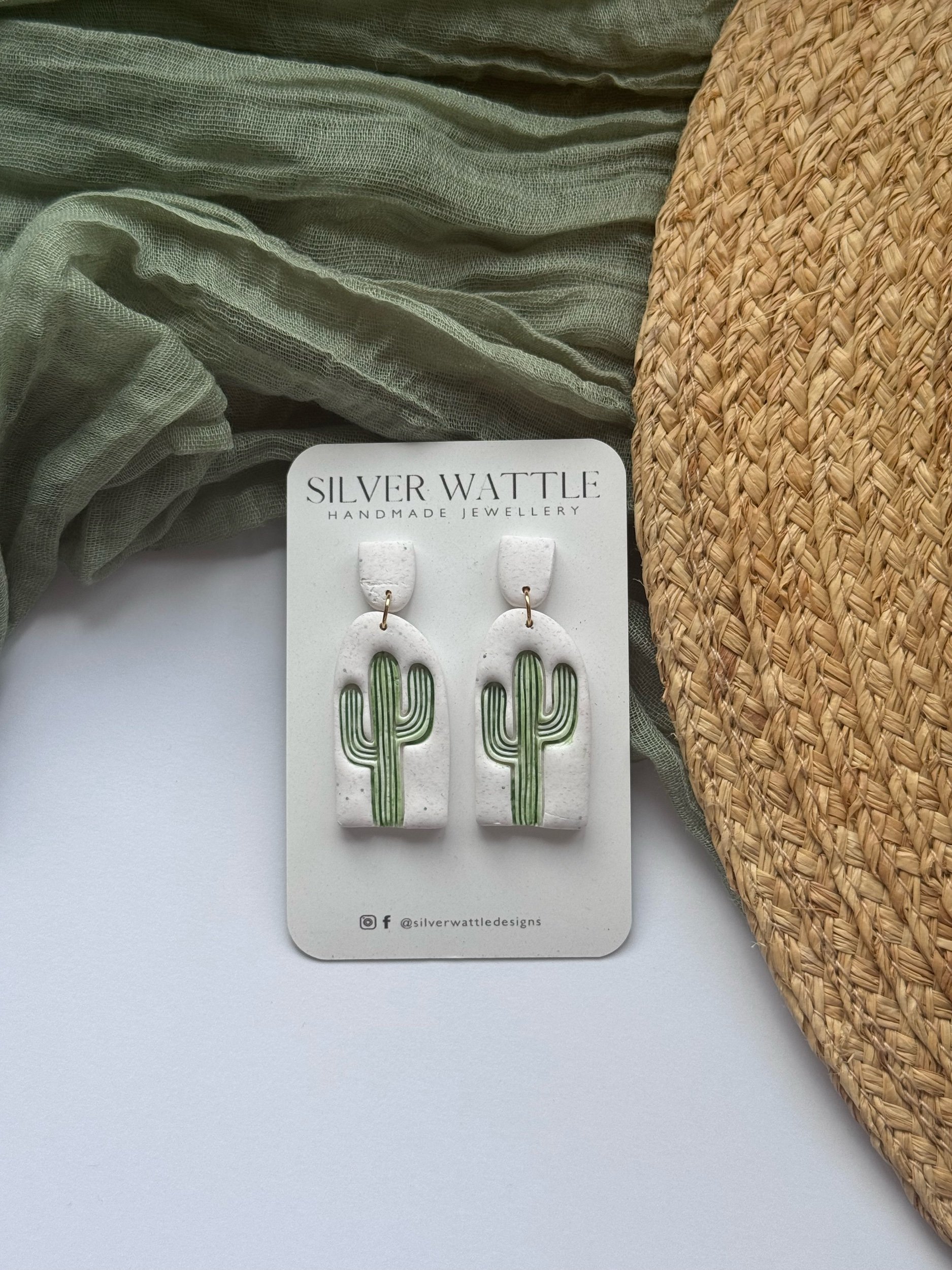 A handcrafted pair of cactus-shaped earrings with green detailing on made from polymer clay from Silver Wattle.