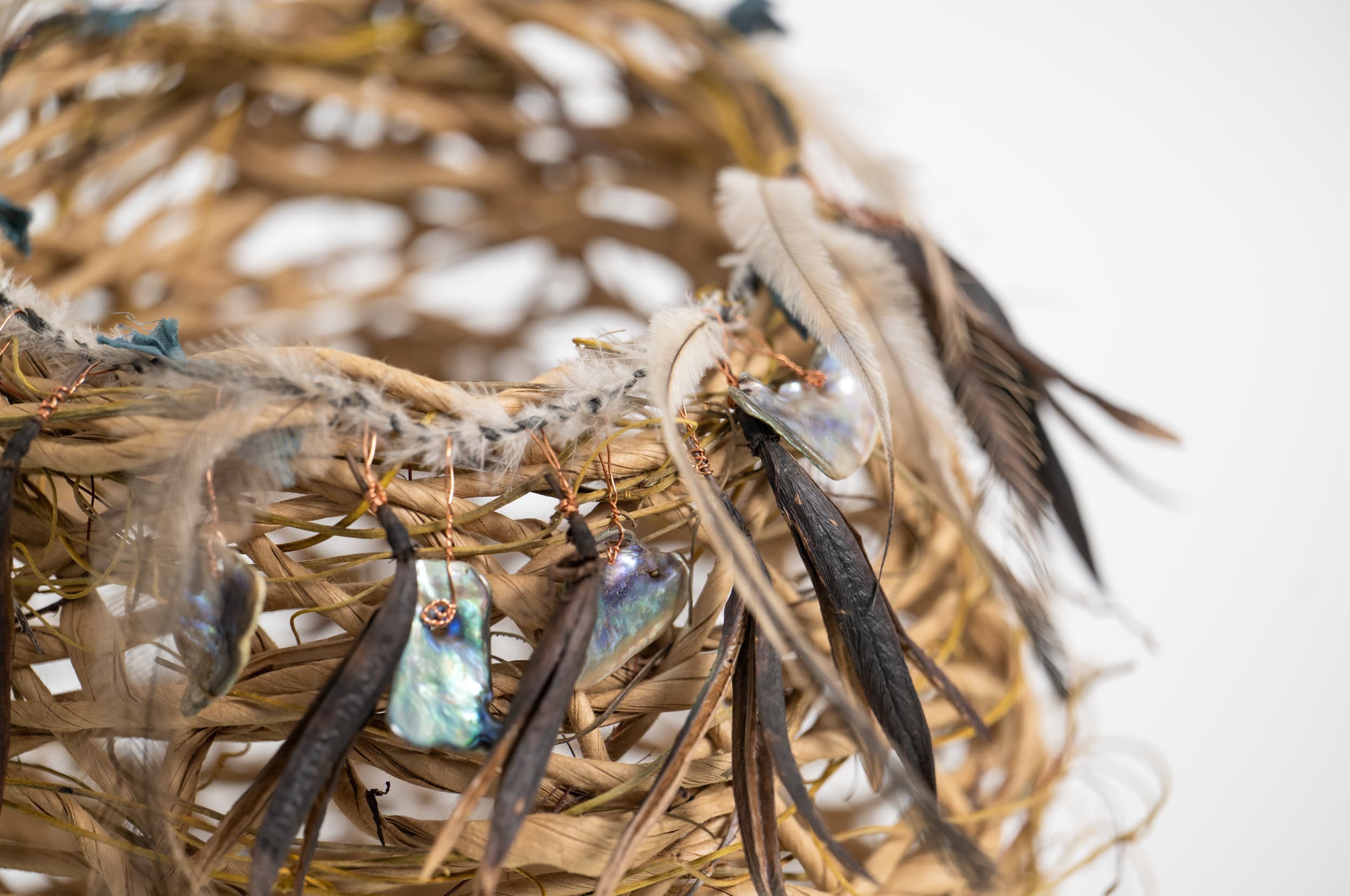 Random weave basket made with paper rope, dodder vine, wire, New Zealand paua shell, flax flower seed heads, and Australian emu feathers.
