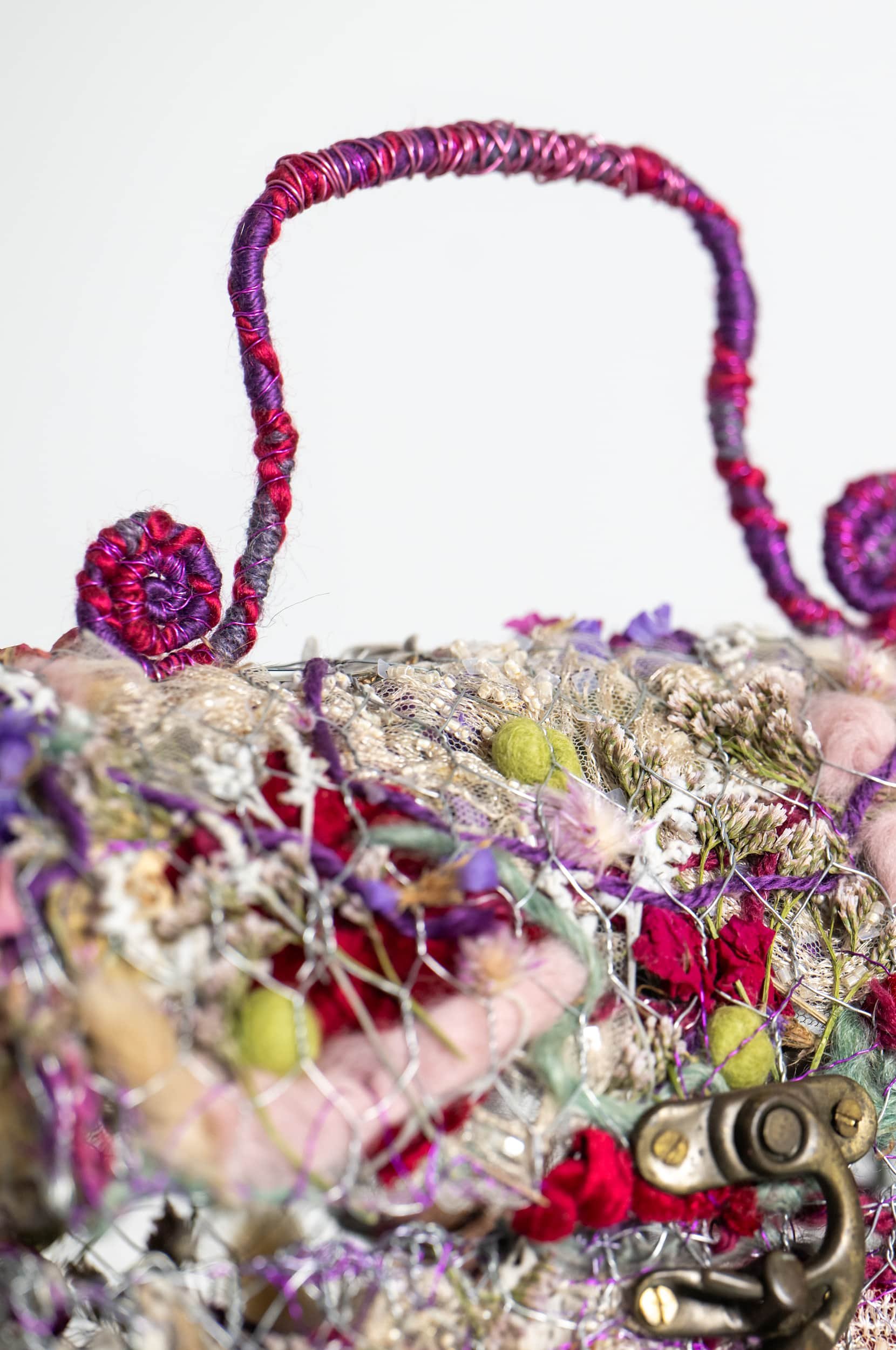 Layered chicken wire construction with assorted dried leaves, seed pods, flowers, grasses, felt balls, wire, shells, paua shells, and recycled lace, velvet, and wool.